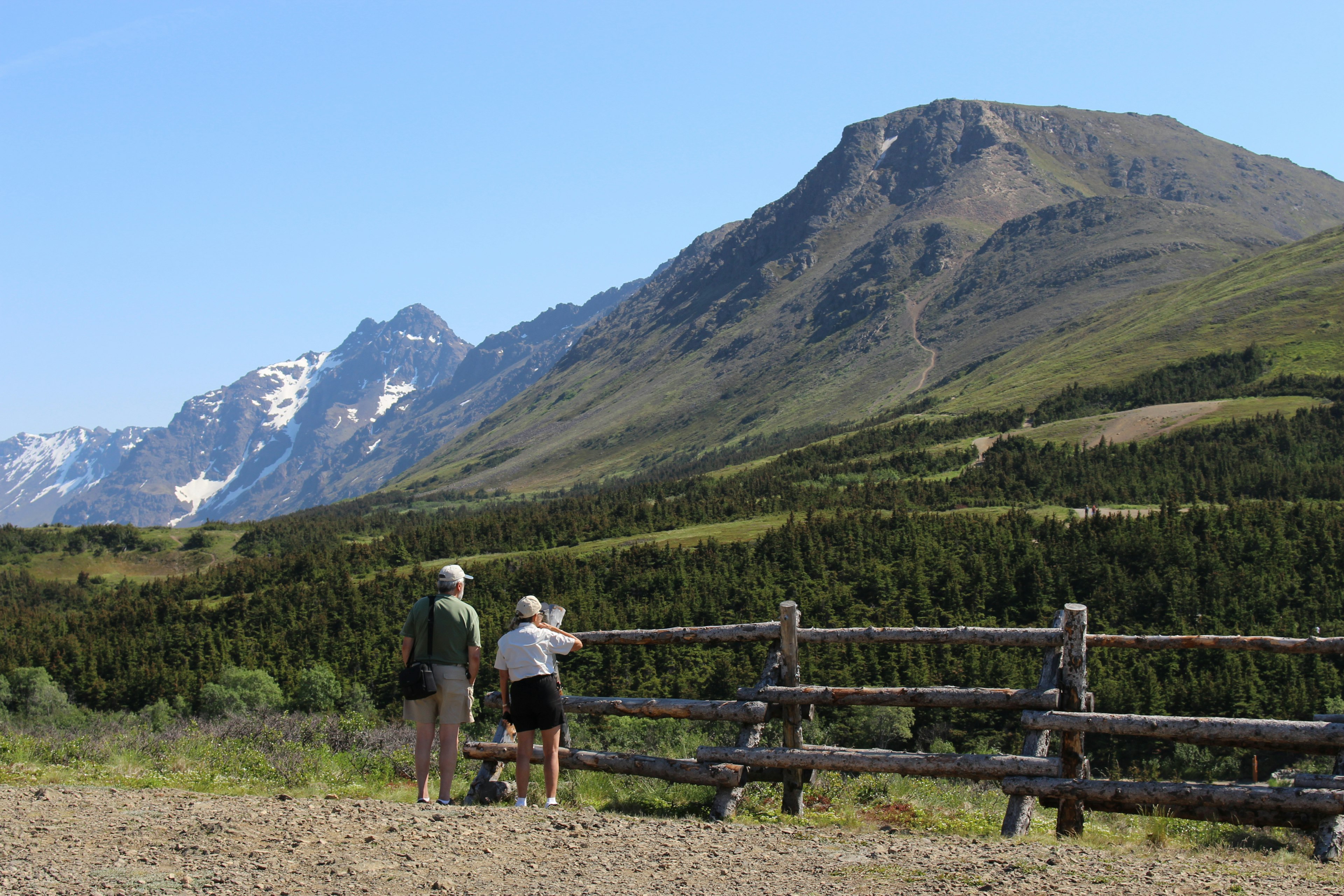 The summit of Flattop looms to the right of two hikers