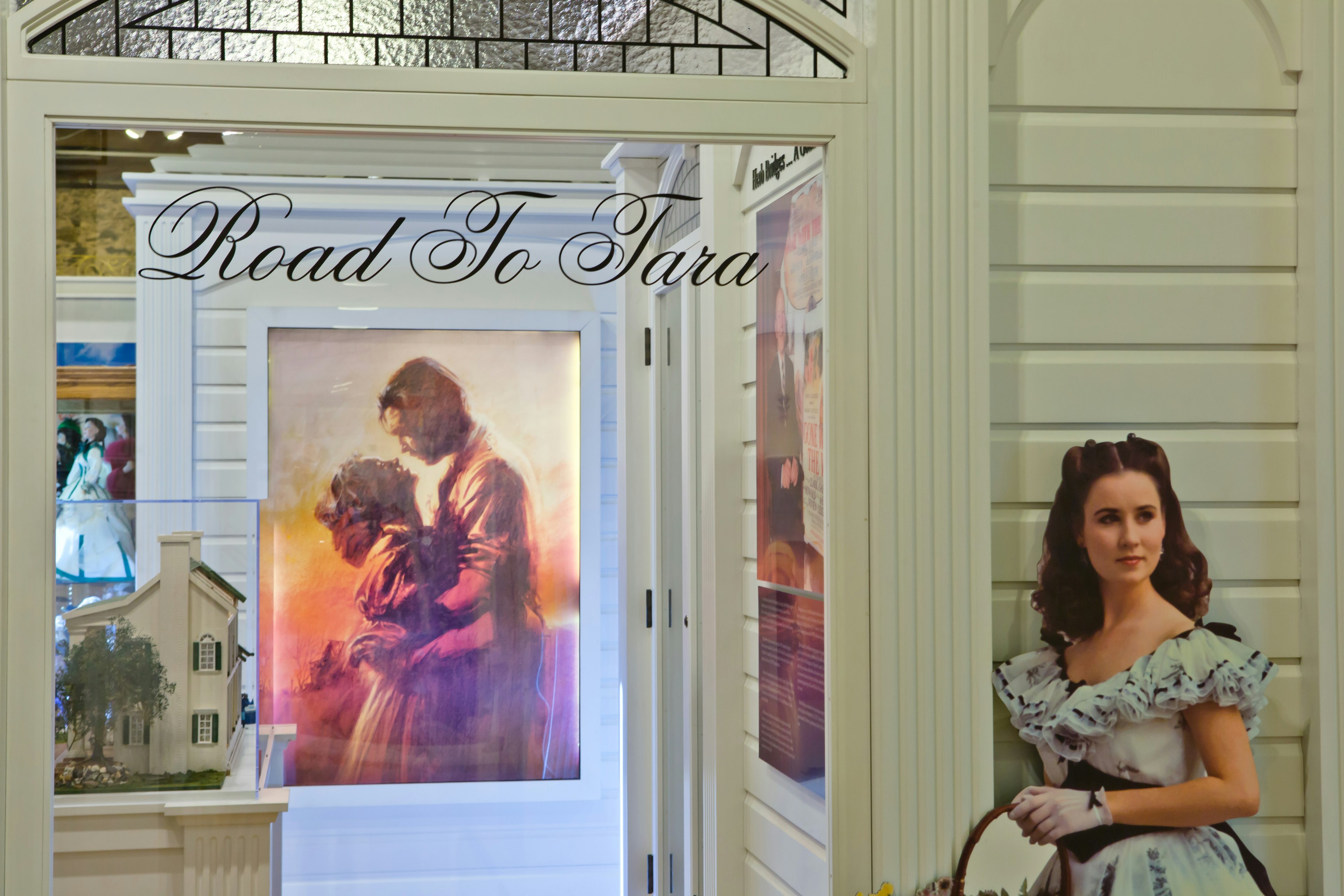 The Gone with the Wind museum, in Georgia. A white door with a glass panel is in shot; 'the road to Tara' is written on it. A cardboard cutout of a character from the movie is next to it.