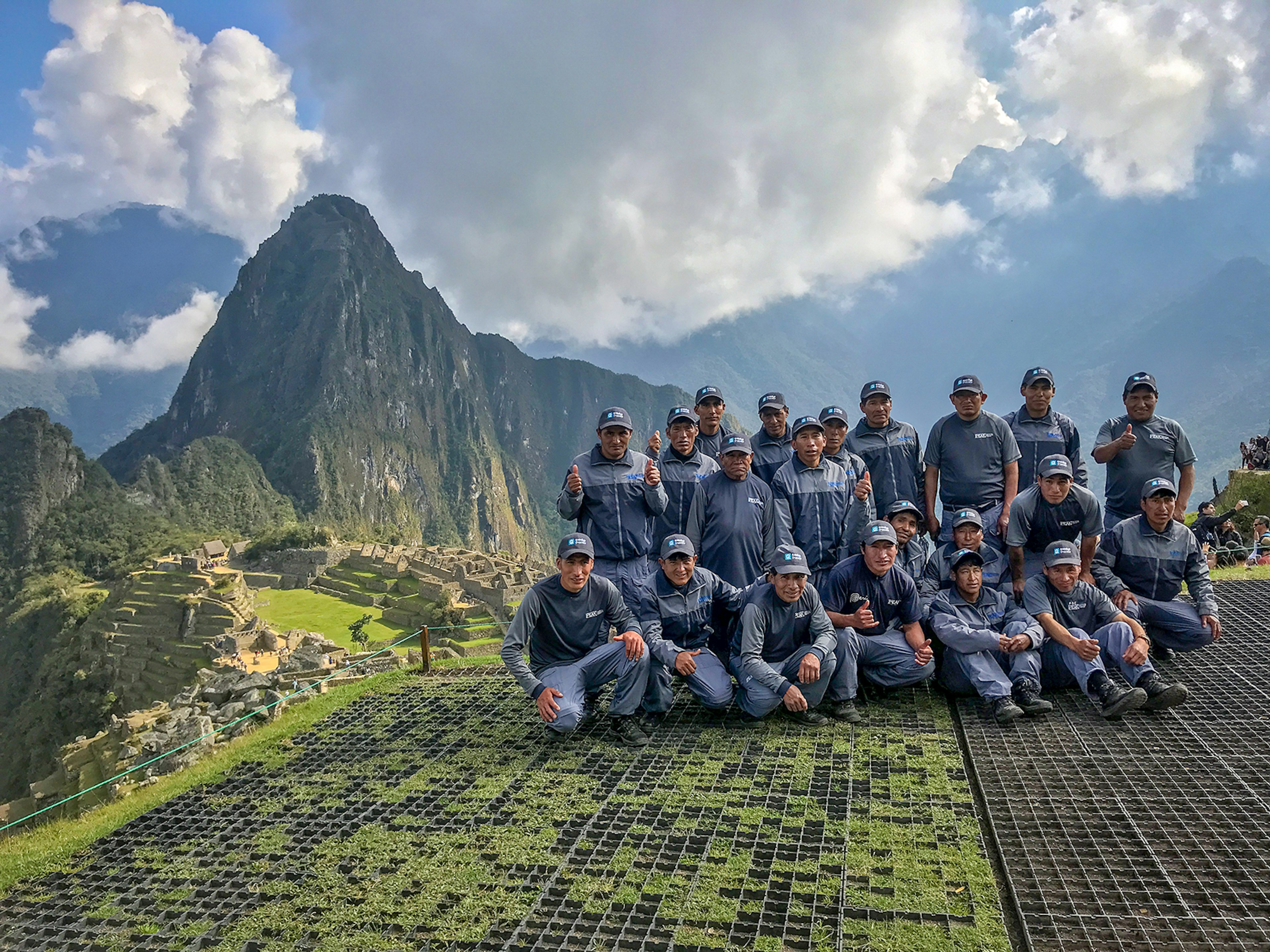 A group of uniformed men pose in front of Machu Picchu