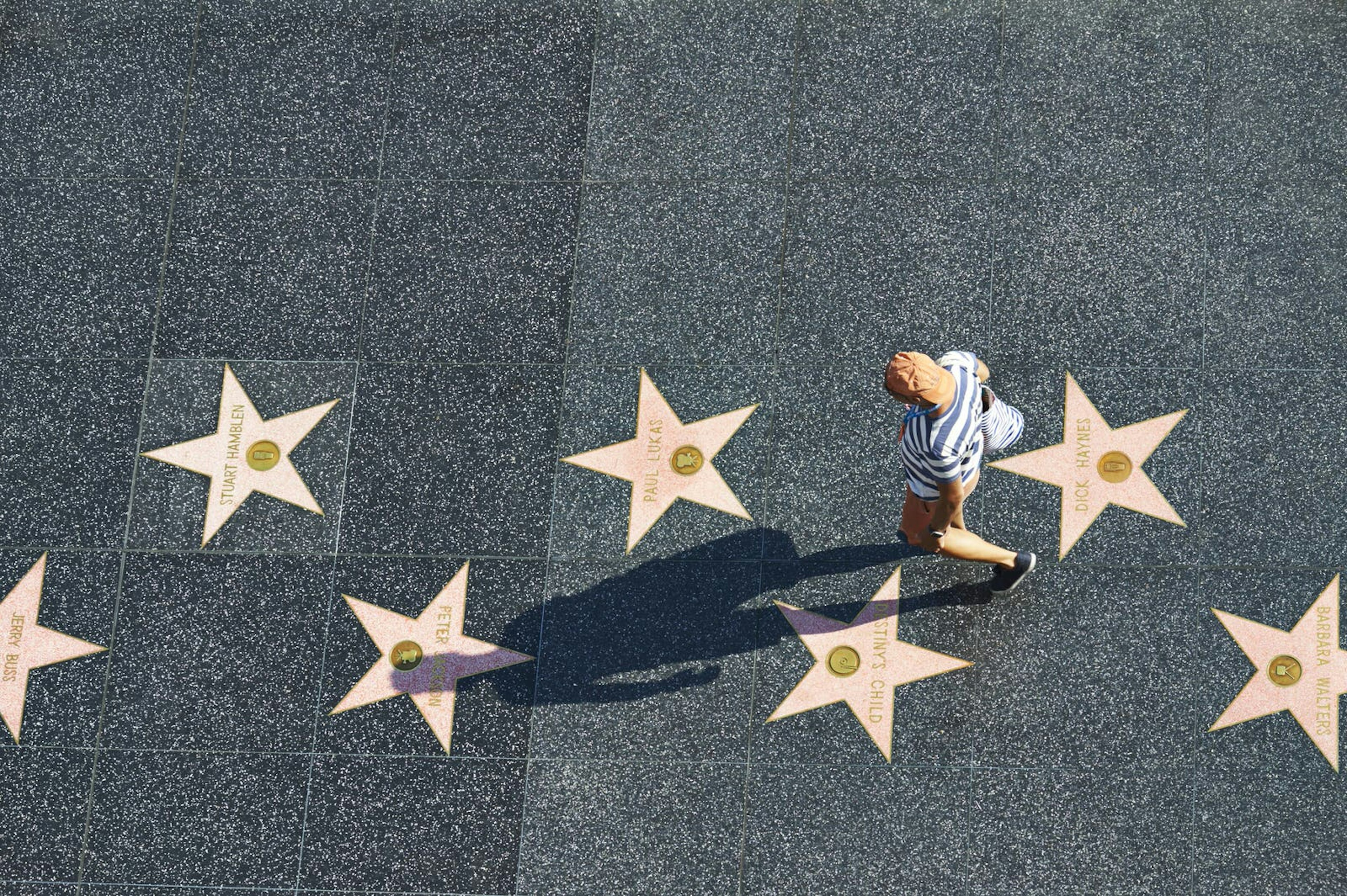 A man walks along Hollywood's Walk of Fame, a section of road emblazoned with celebrities' names written inside gold stars © Simon Urwin / Lonely Planet