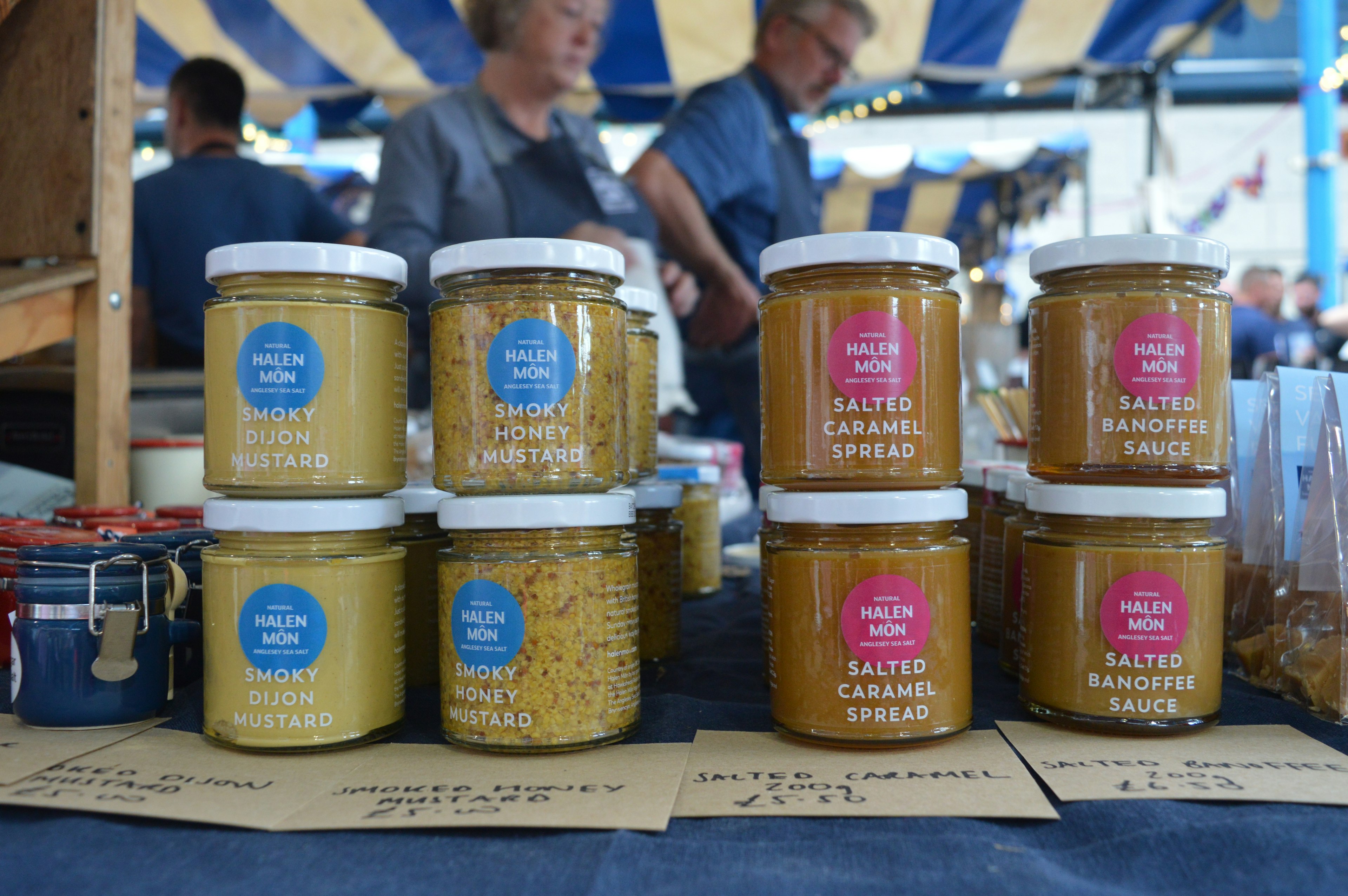 A display of mustards and caramel spreads from the Halen Mon brand.