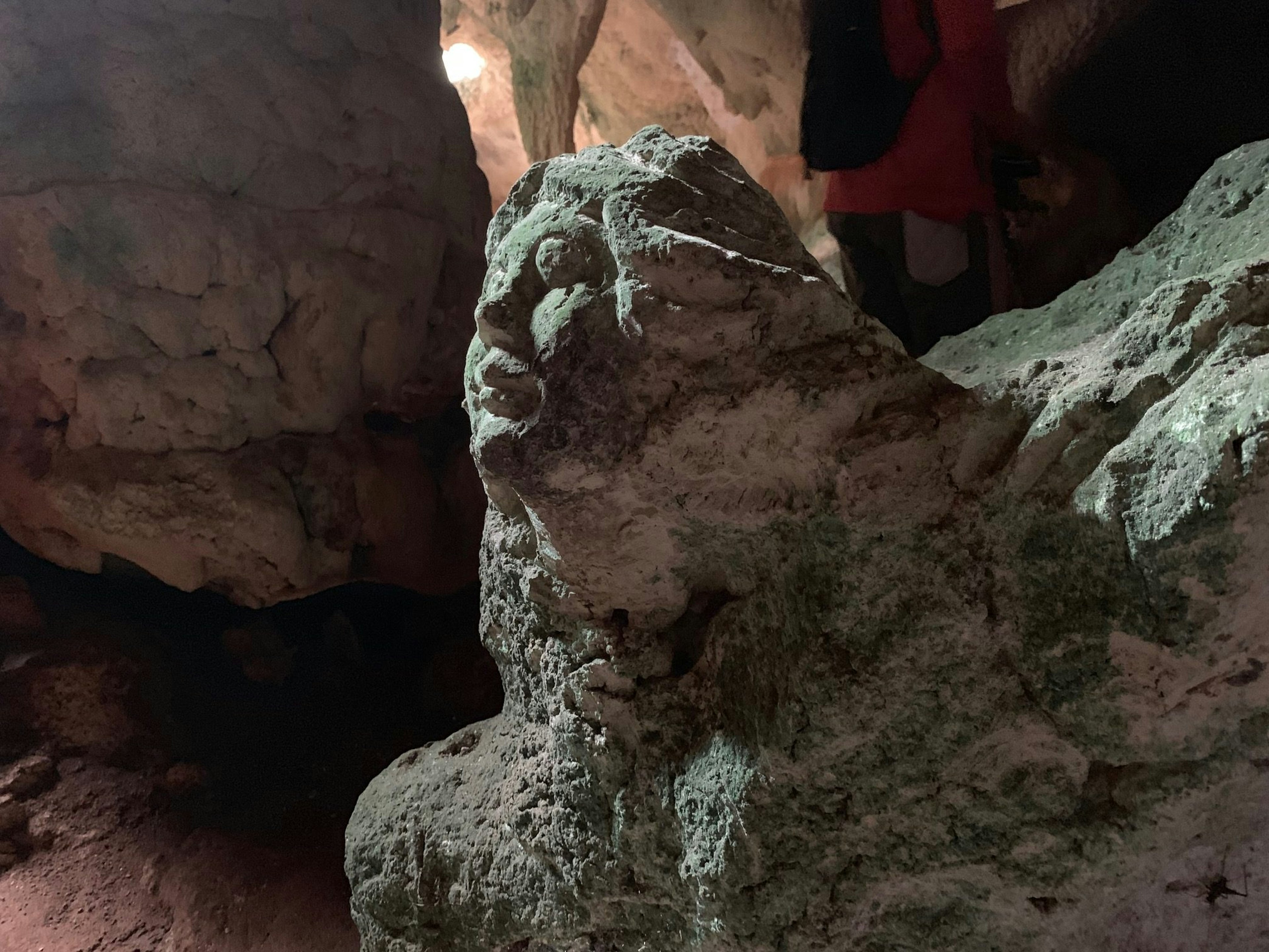 A head and face carved out of stone inside of a cave; Long Island Bahamas