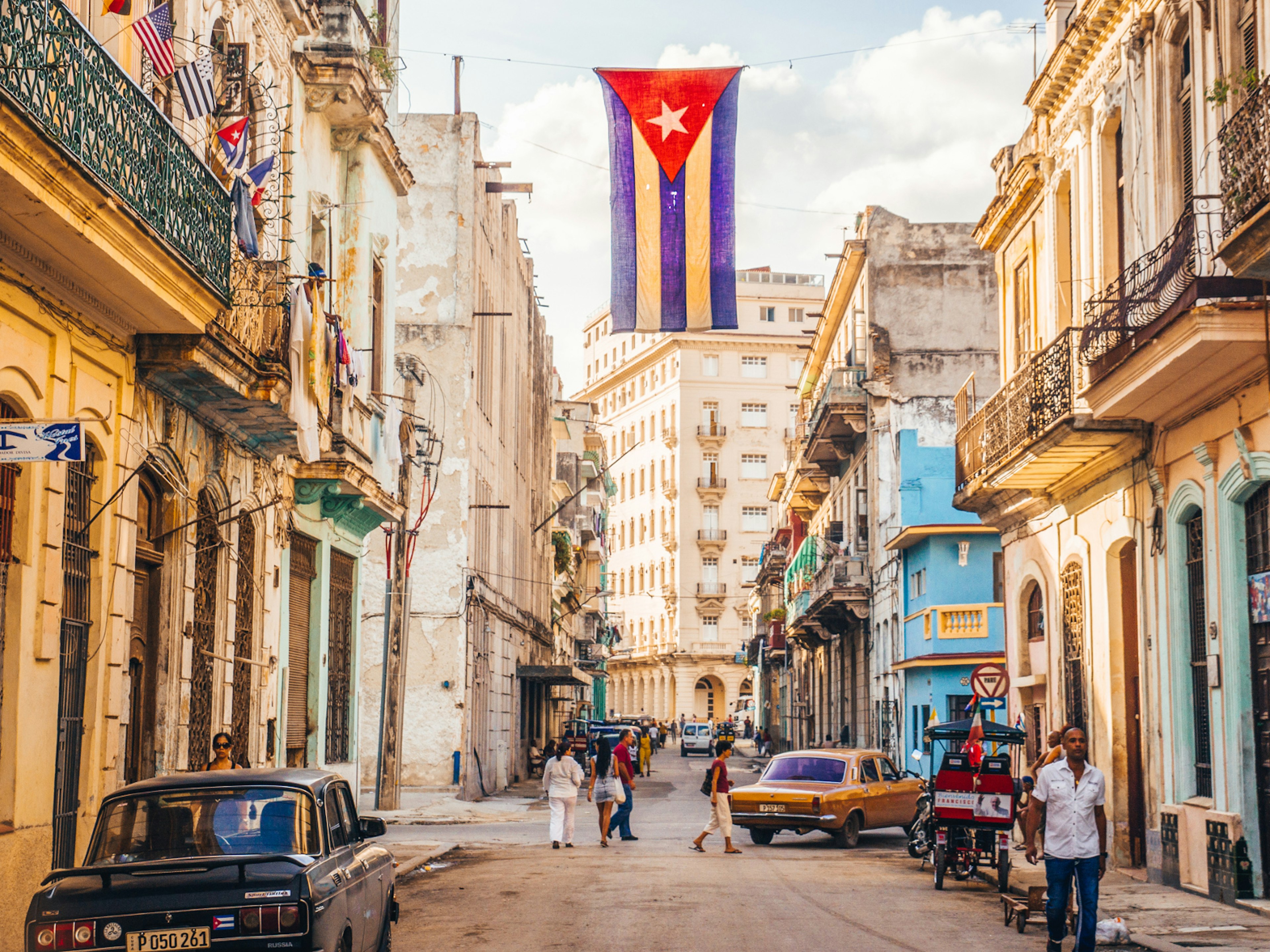 A Cuban flag hangs over a street in Central Havana © julianpetersphotography / Shutterstock