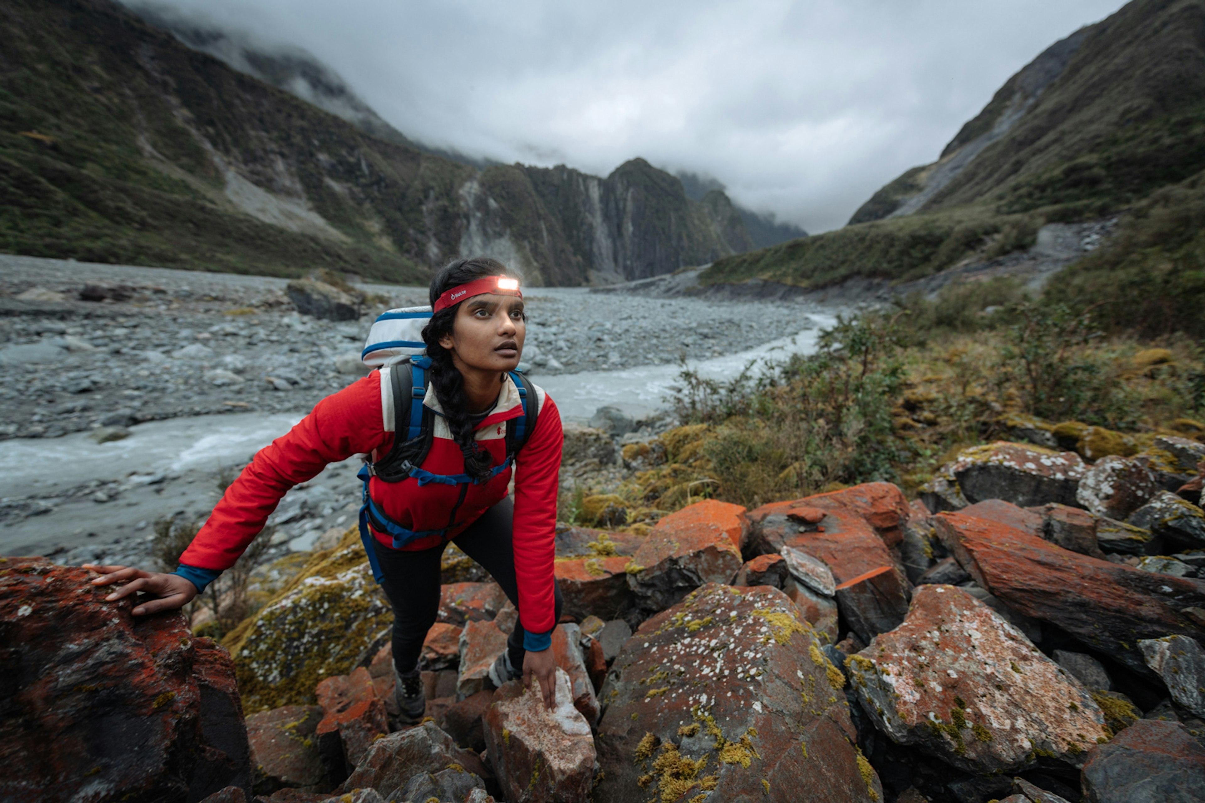 A woman wearing a headlamp looks off camera