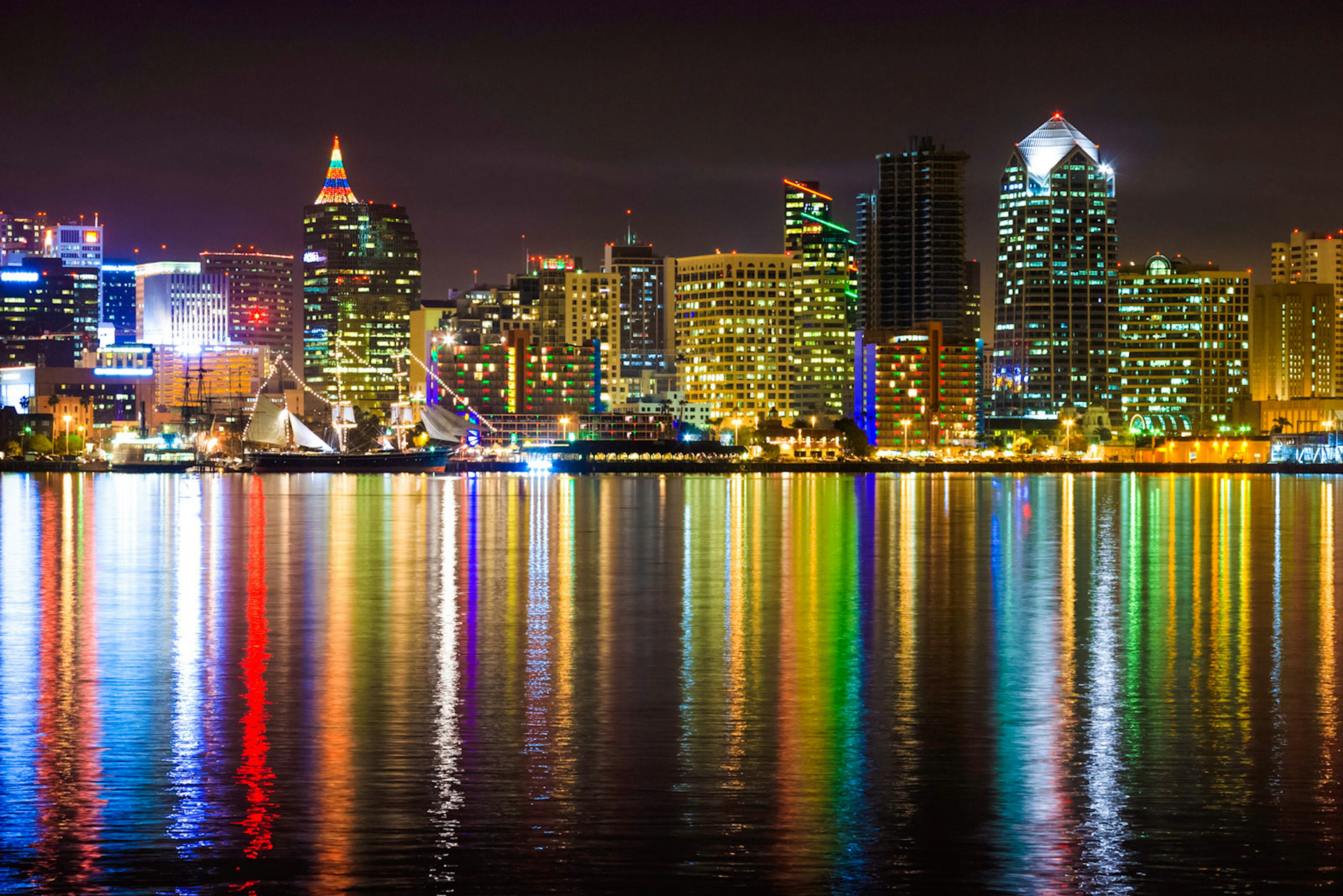 Christmas lights adorn the buildings and boats in the harbor