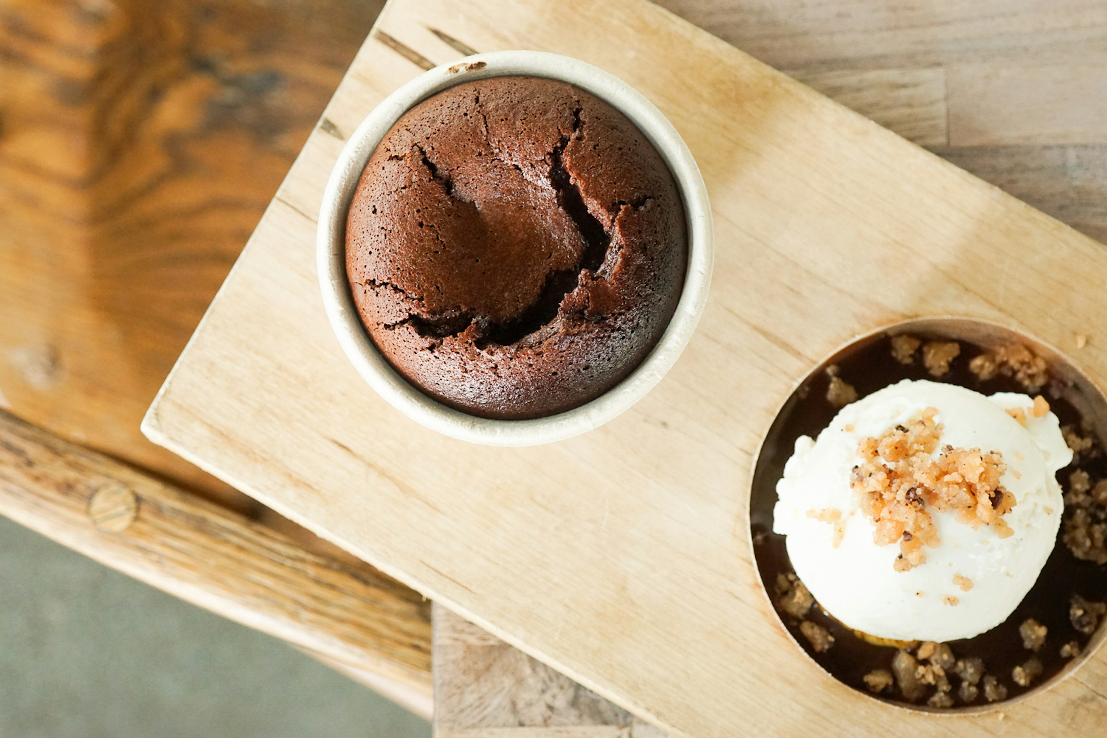 Overhead closeup of a cracked molten lava cake on a wooden board