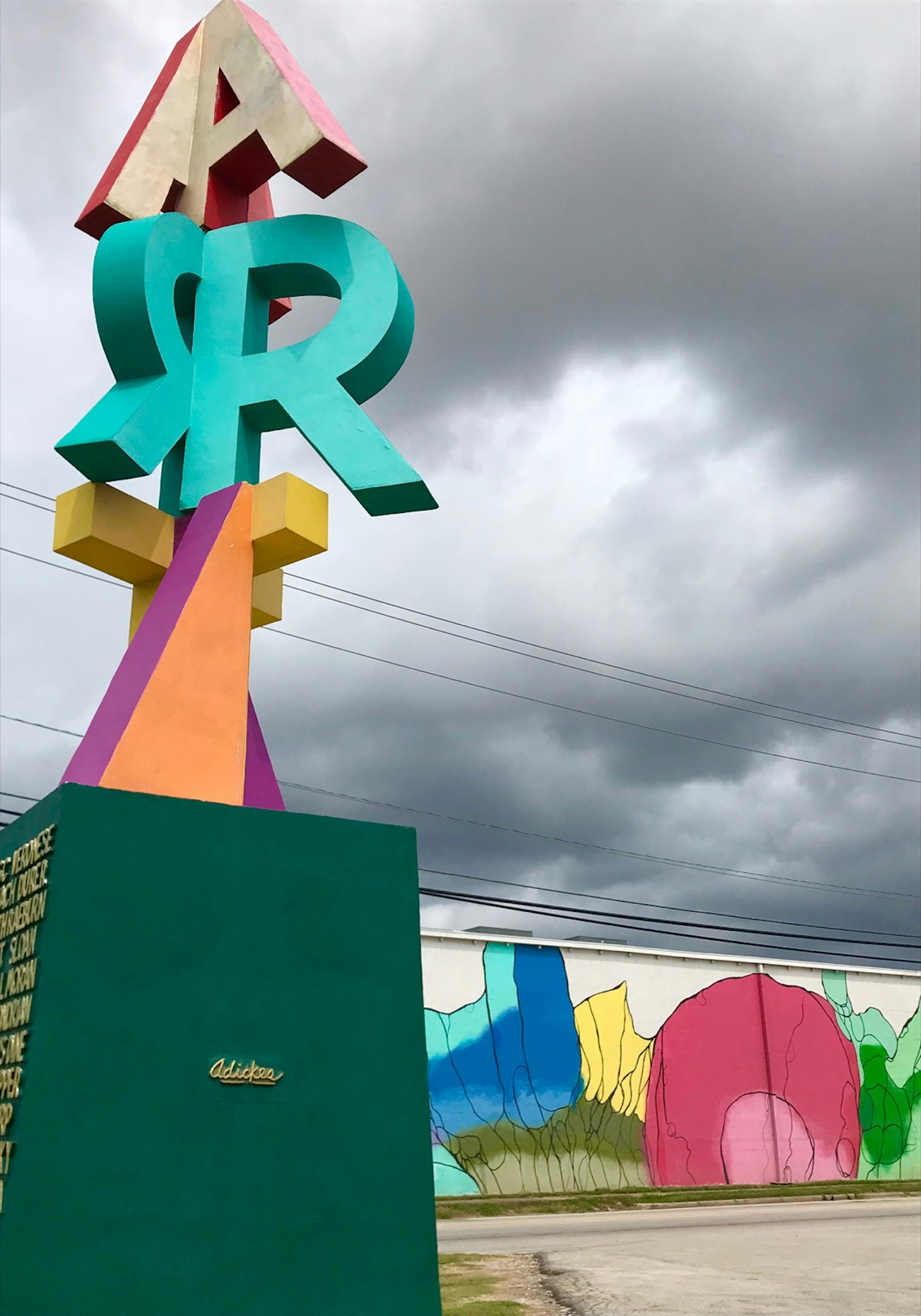 A column of stylized letters spelling 'Art' stands in front of a cloudy gray sky and colorful mural © Lisa Dunford / ϰϲʿ¼