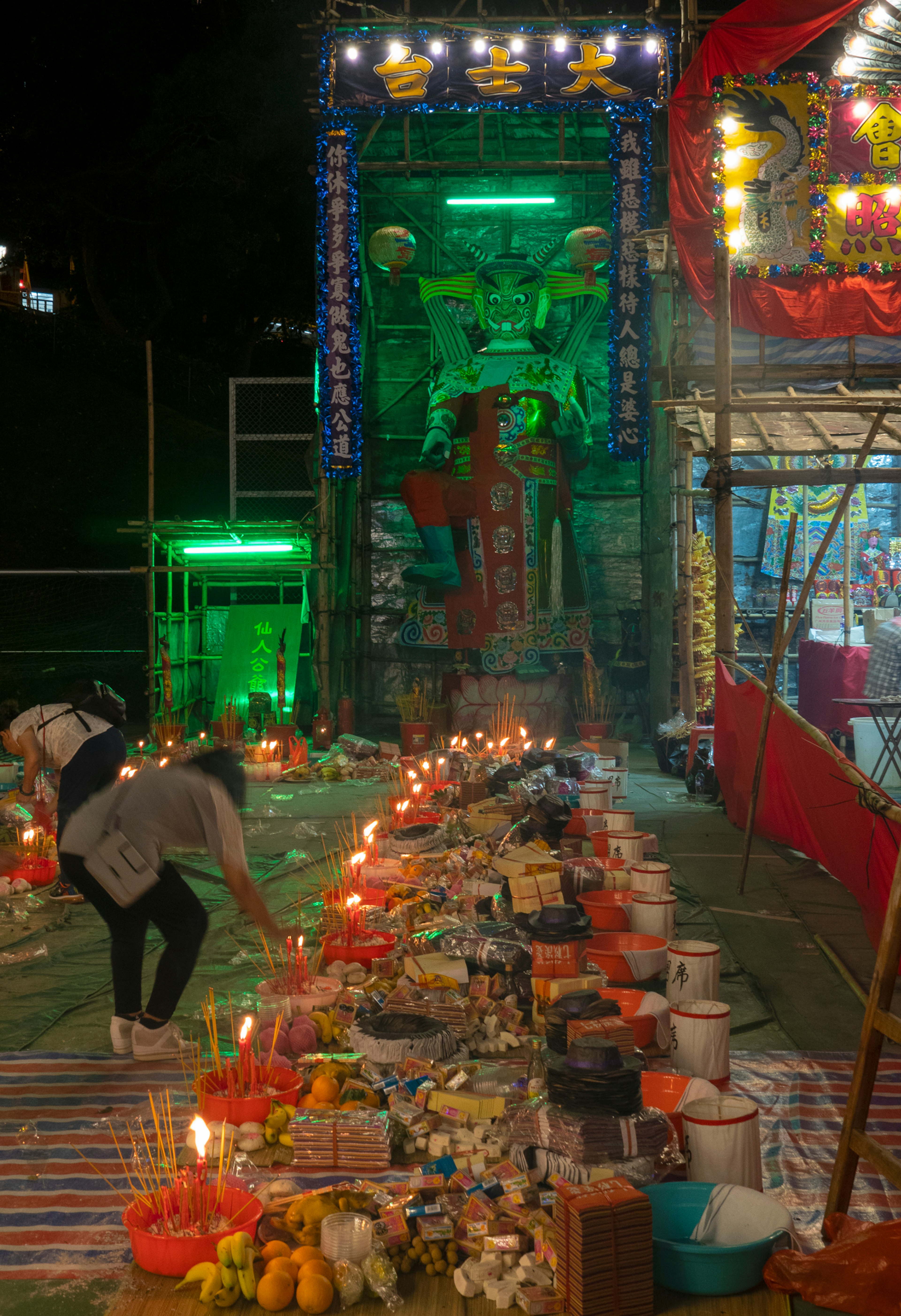 A woman lighting an incense stick on the street in Hong Kong to ward off angry spirits during the Hungry Ghost Festival