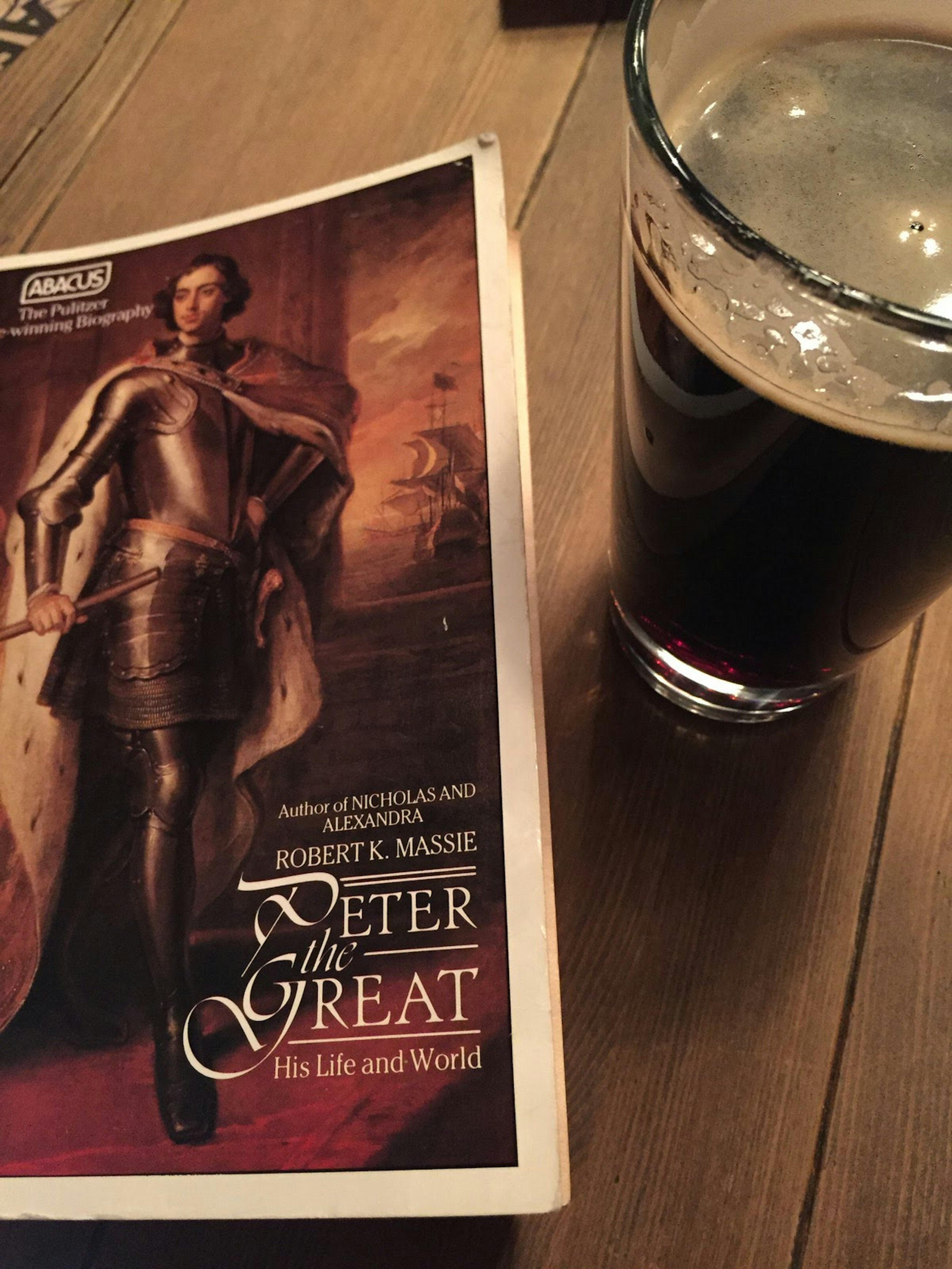 A book of Robert K Massie's Peter the Great on a table next to a pint of dark beer © Megan Eaves / Lonely Planet