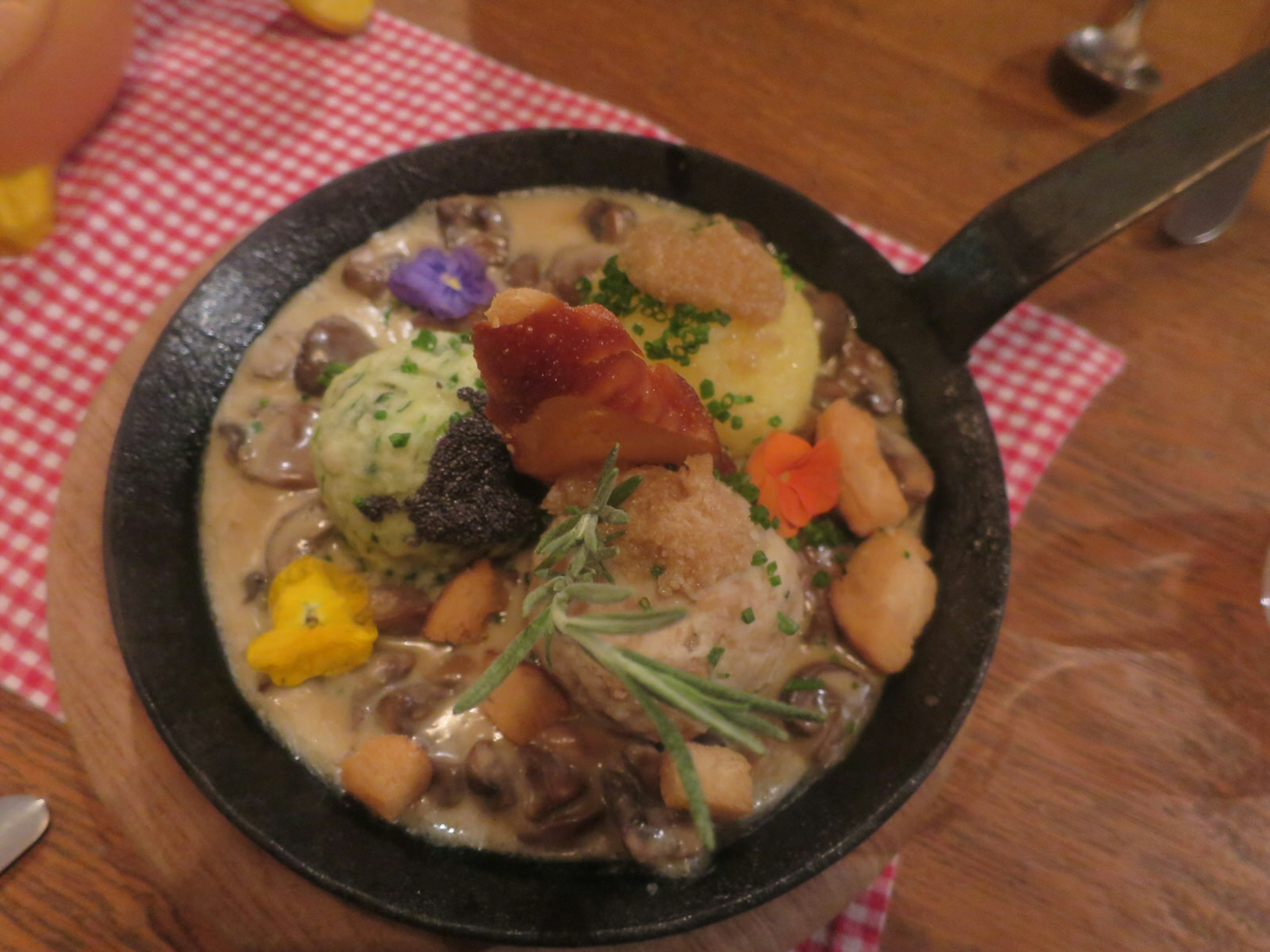 Traditional dish of dumplings -- both potato and bread versions -- at Ehrbar Weinstube, Frickenhausen. The dish is served in a small, iron fying pan and decorated with edible flowers and thyme