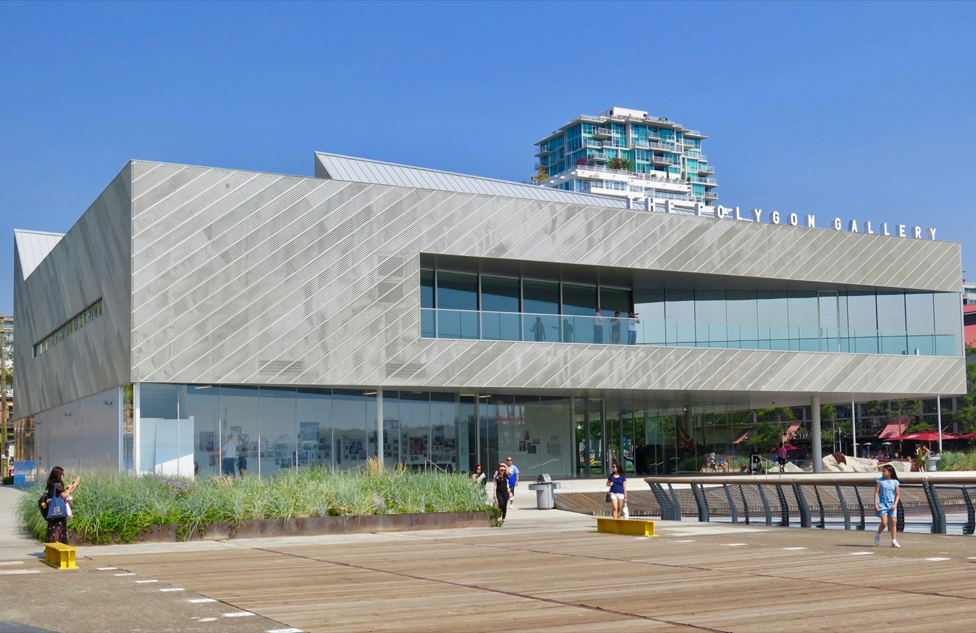 The modern facade of an art gallery, with angled gray wood and long rows of inset windows dominates the foreground with other building rising behind © John Lee / ϰϲʿ¼