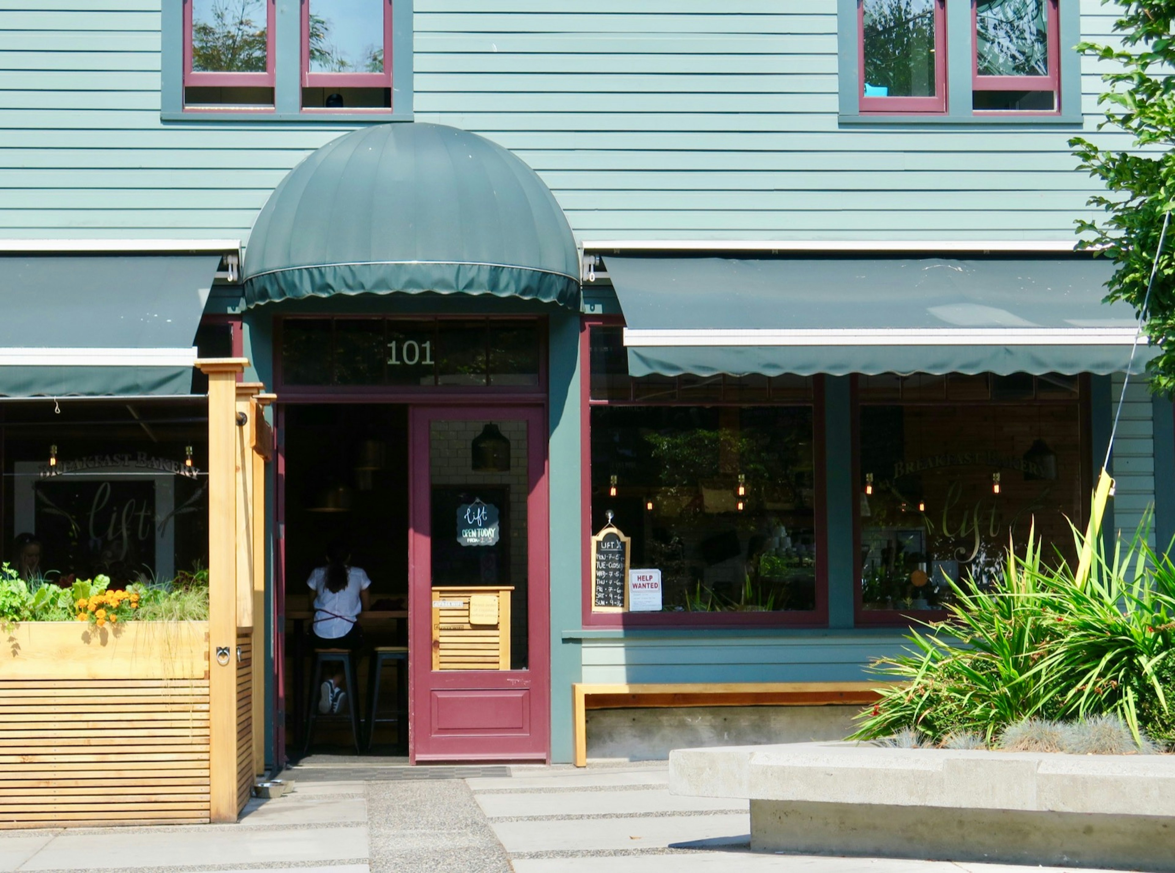 A green awning tops a red door as customers enter a small restaurant © John Lee / Lonely Planet