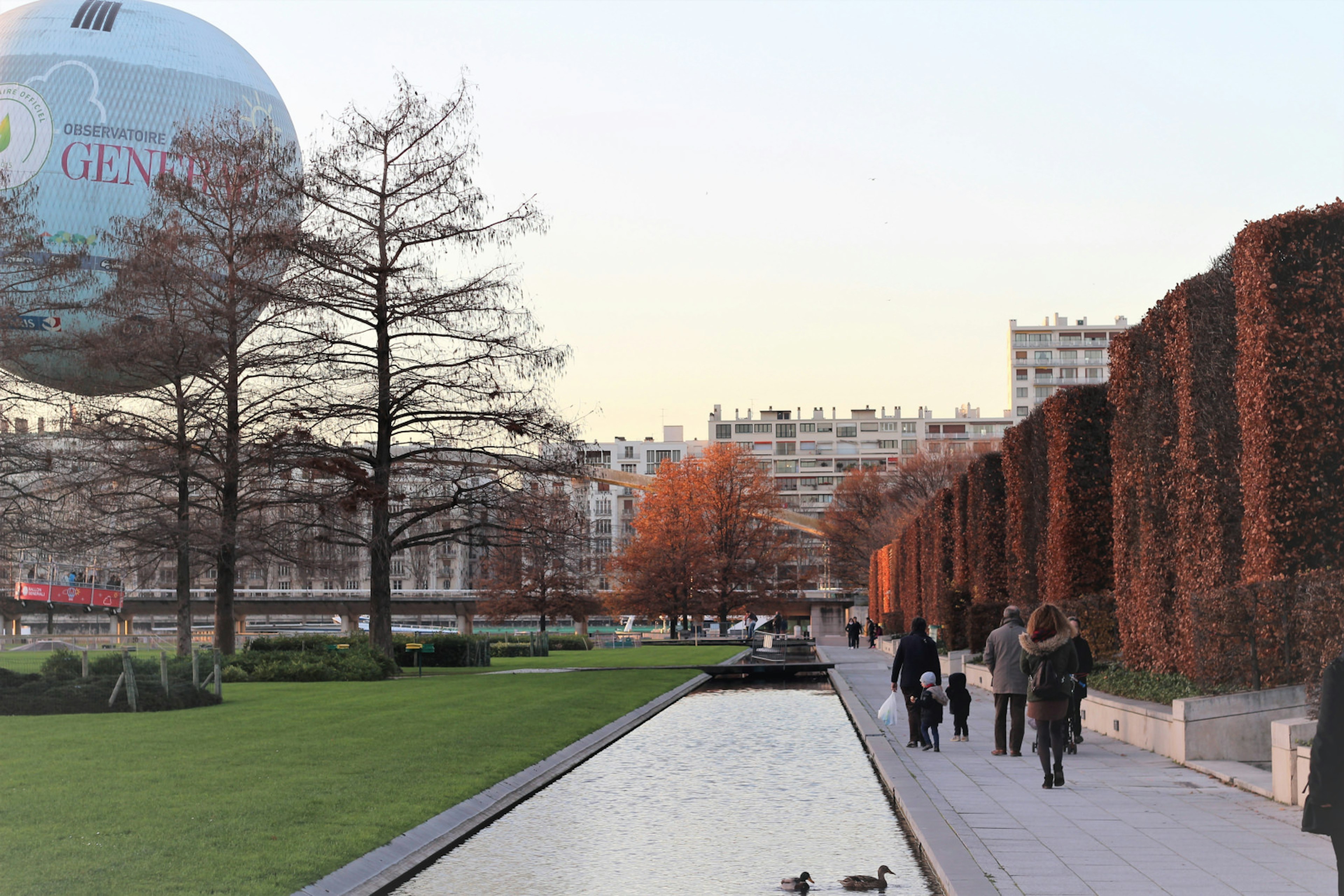 The Ballon de Paris hot air balloon floats an autumnal Parc André Citroën as the sun starts to set