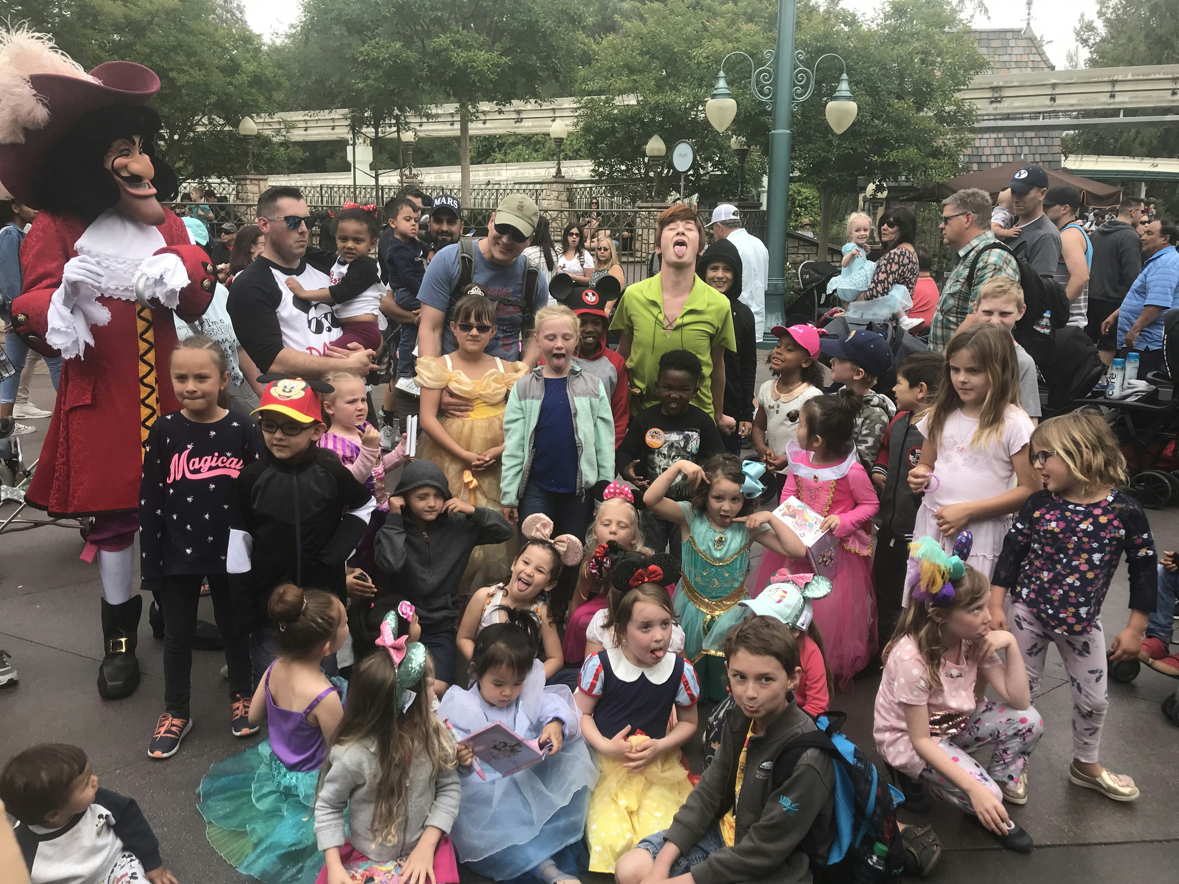 Peter Pan sticks his tongue out with a bunch of kids at Disneyland in California