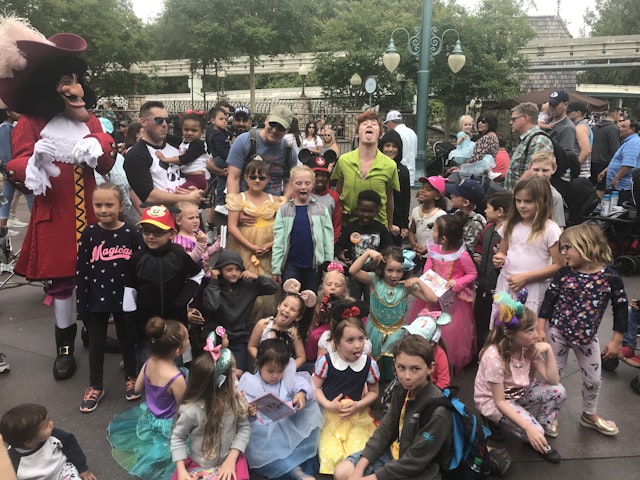 Peter Pan sticks his tongue out with a bunch of kids at Disneyland in California