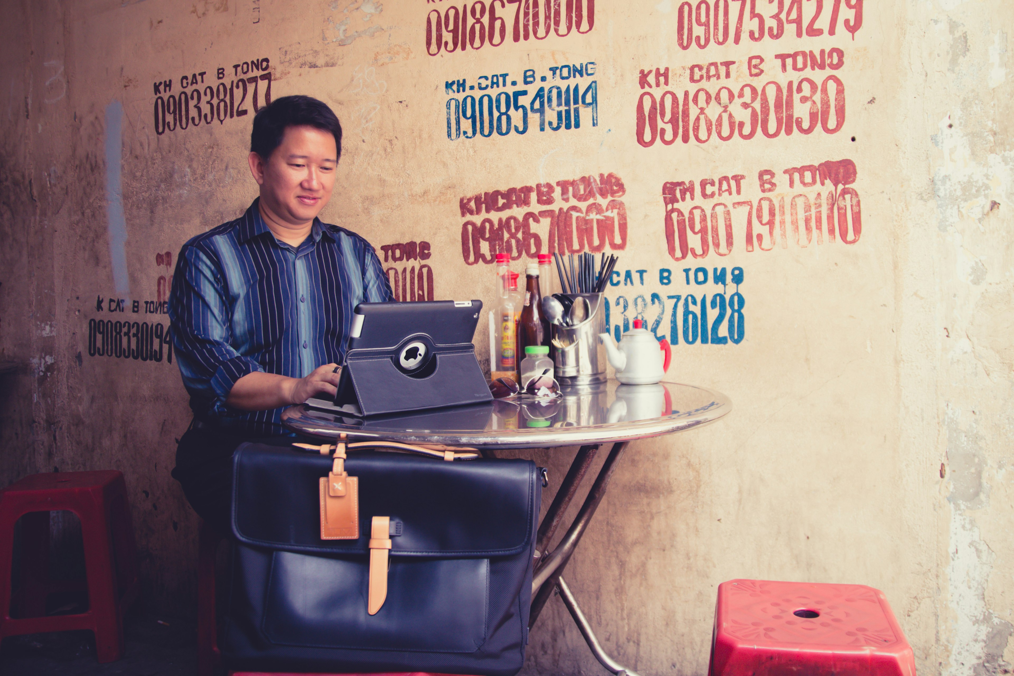 James Pham sits at a small table working on his computer.