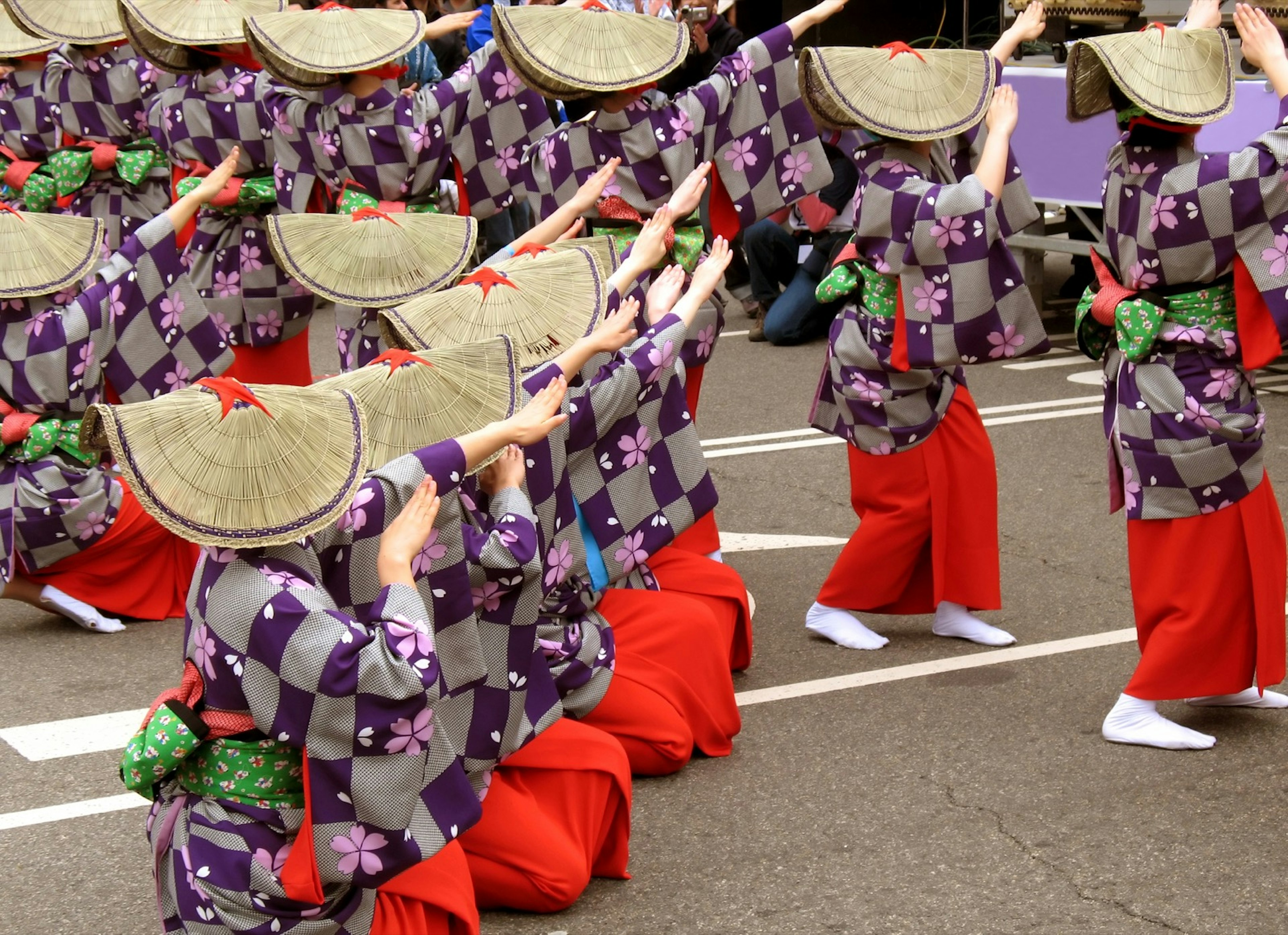 Dancers in hats and navy costumes dance in a parade