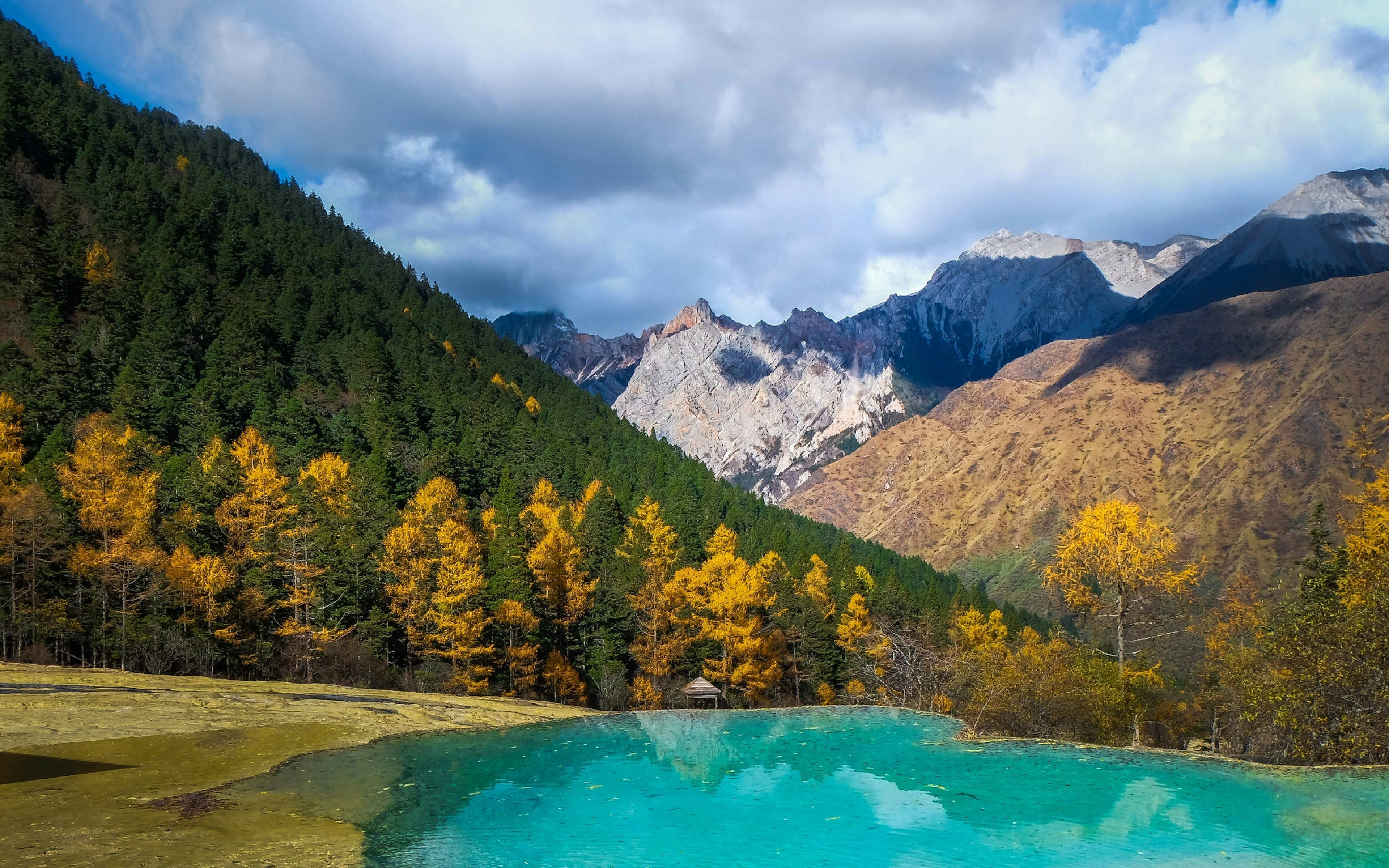 An emerald lake and mountains in autumn.