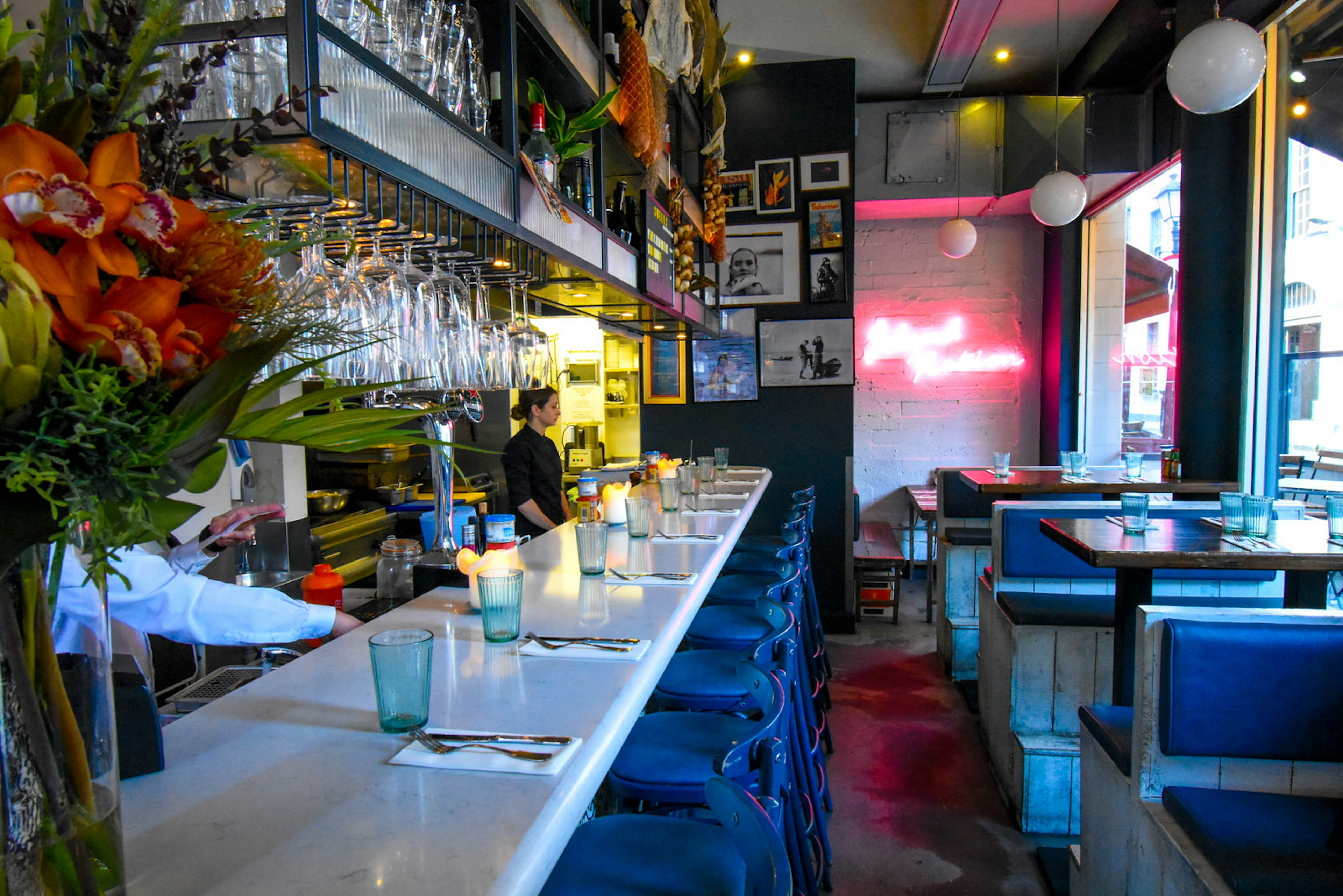 Interior of seafood restaurant, Klaw, in Dublin with white tiles and a pink neon sign