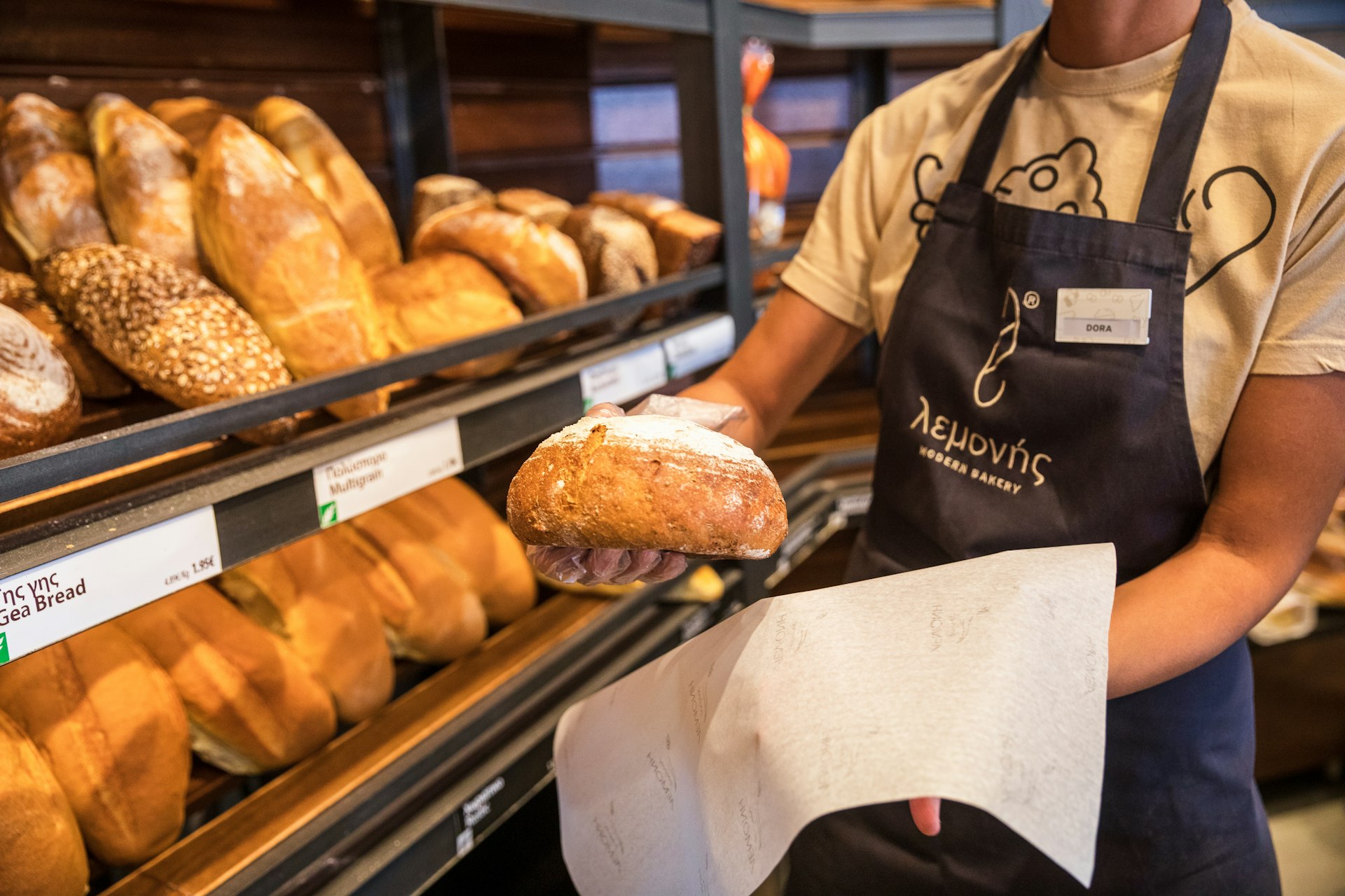 Man holding a loaf at Lemonis bakery, Nea Potidaia Halkidiki in Greece