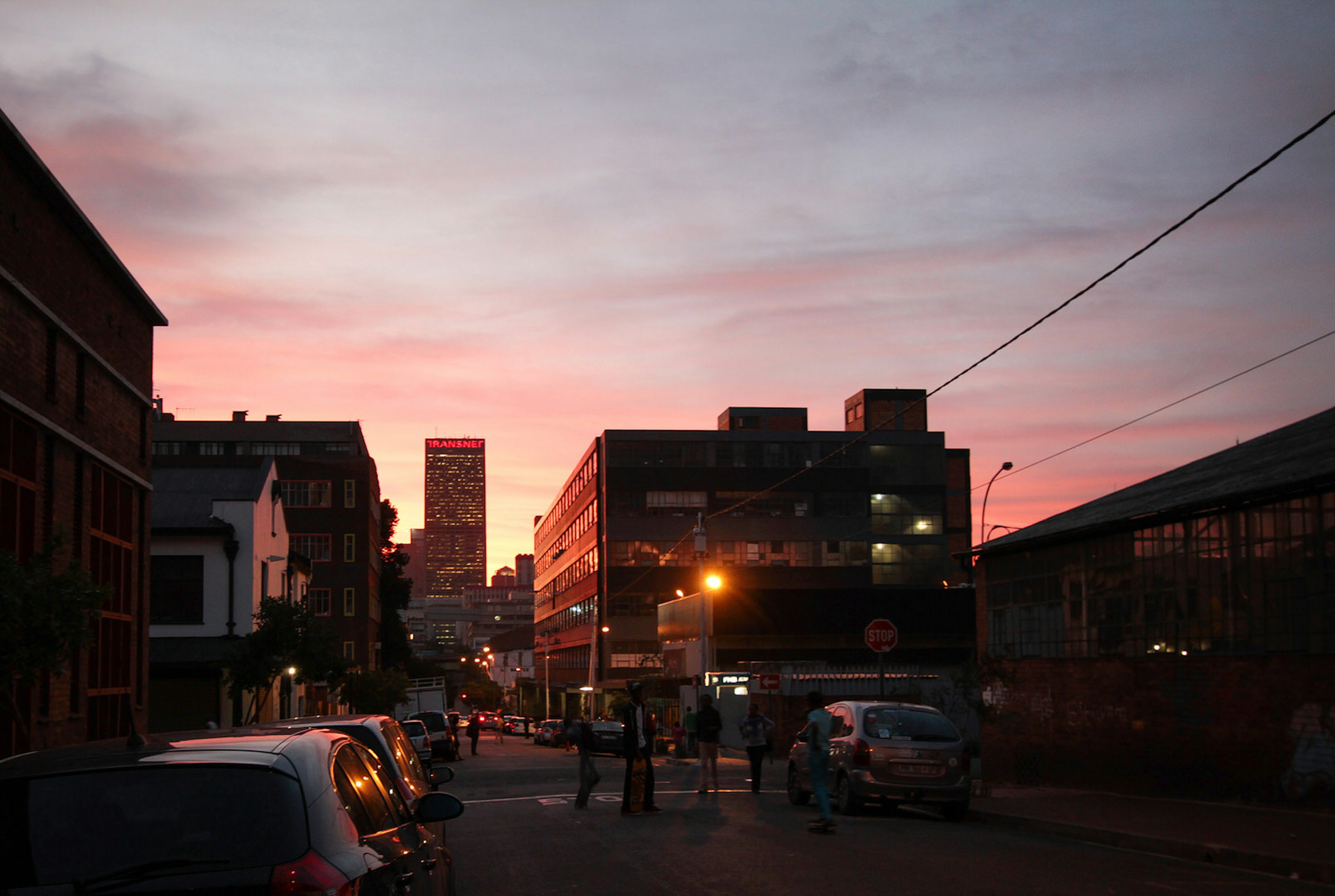 A shot of an intersection, with a bright pink-and-orange sky backing the surrounding buildings and traffic. Maboneng is one of Johannesburg's best neighourhoods © Heather Mason / ϰϲʿ¼