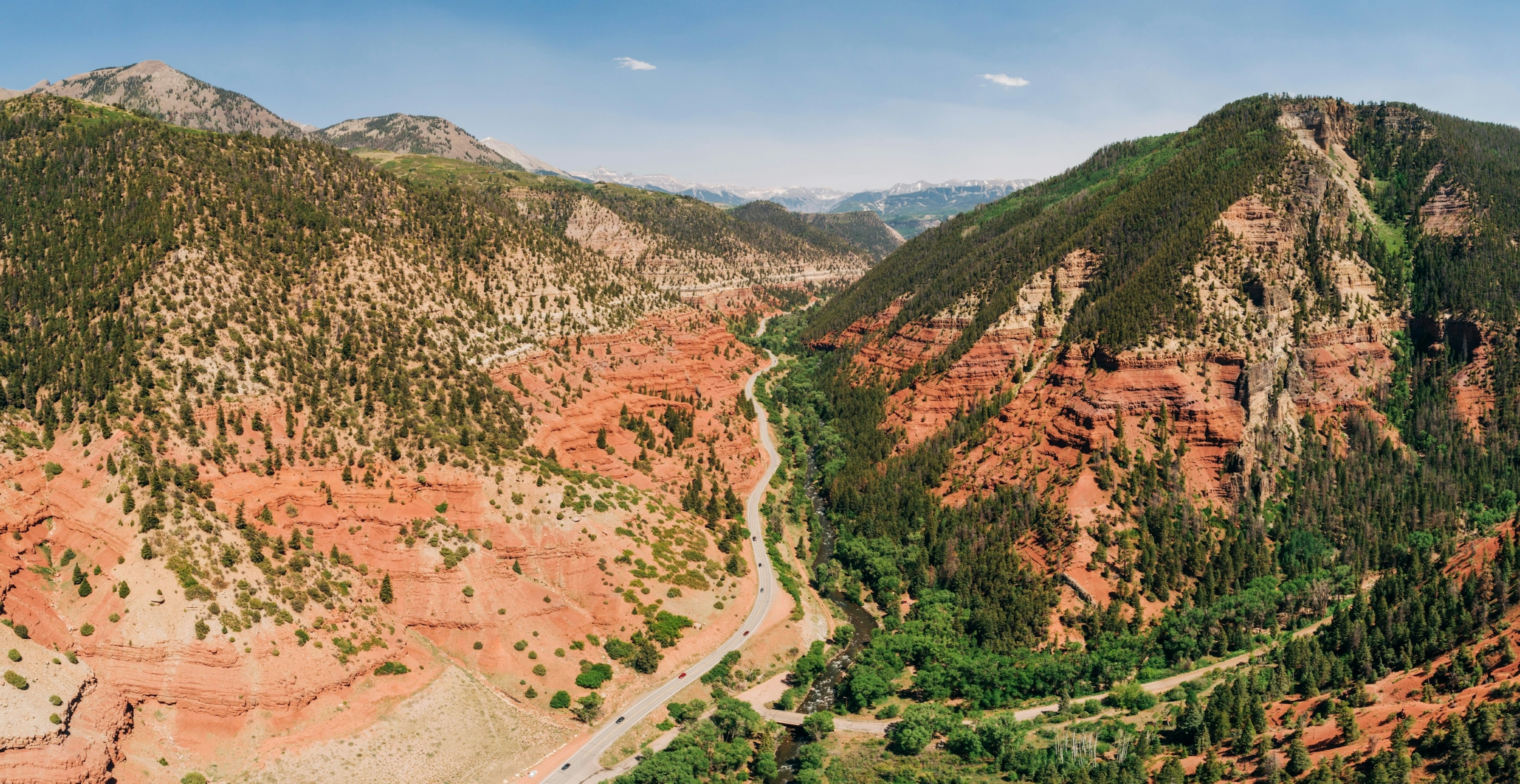 A road snakes between red rock mountains