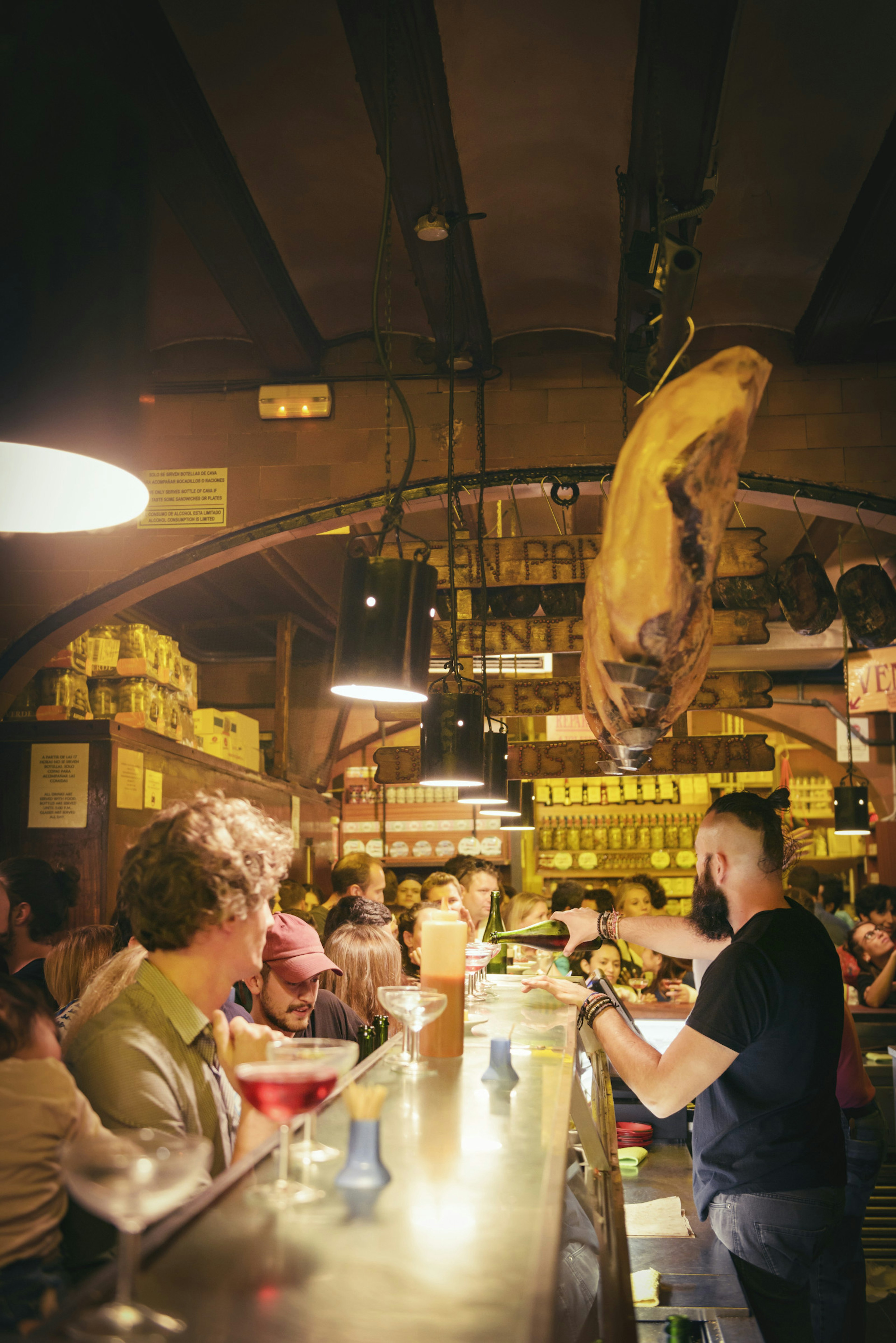 A bartender pours sparkling rose wine to customers at La Xampanyeria © Jonathan Stokes / Lonely Planet