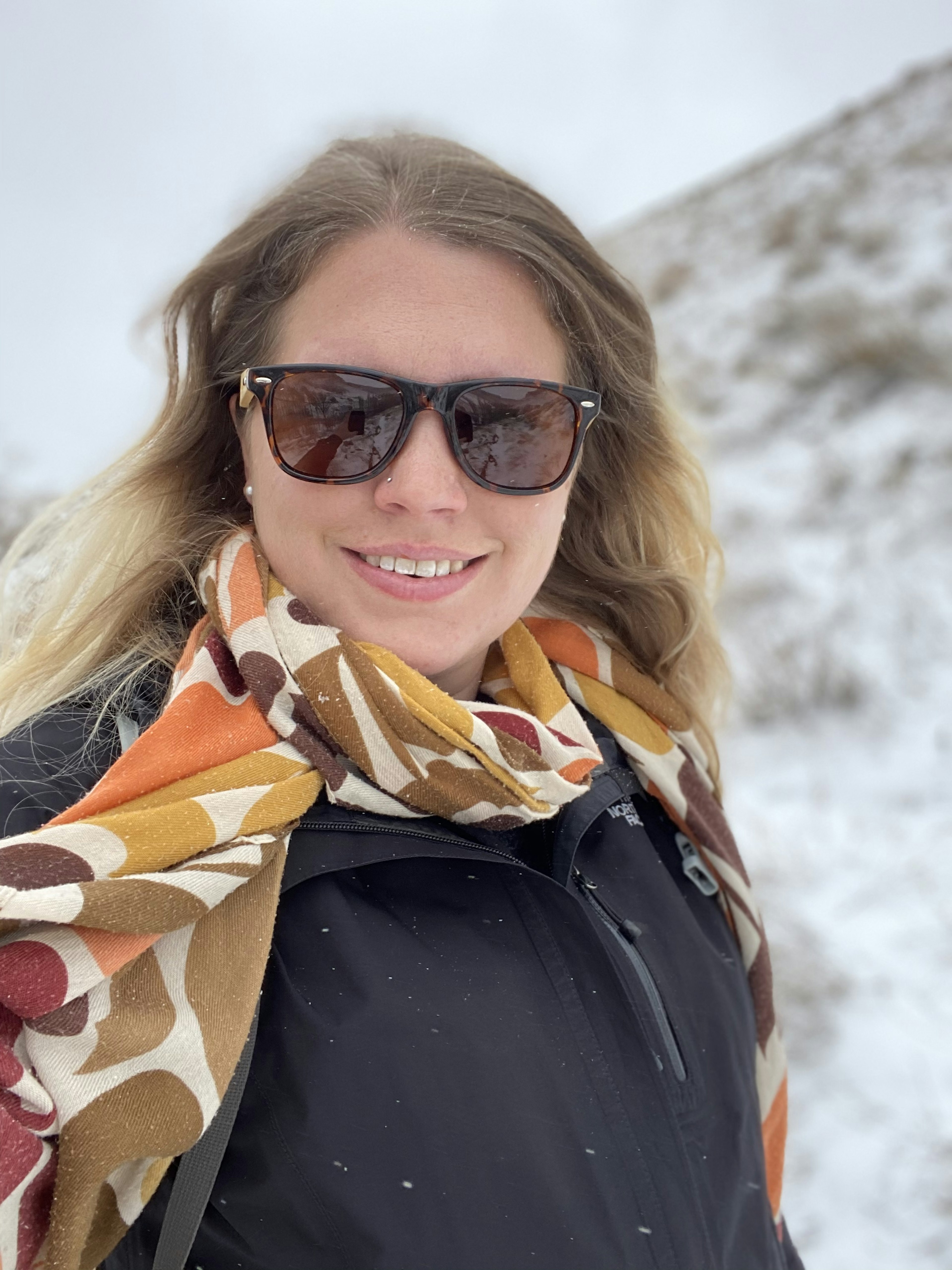 A woman in sunglasses looks at the camera