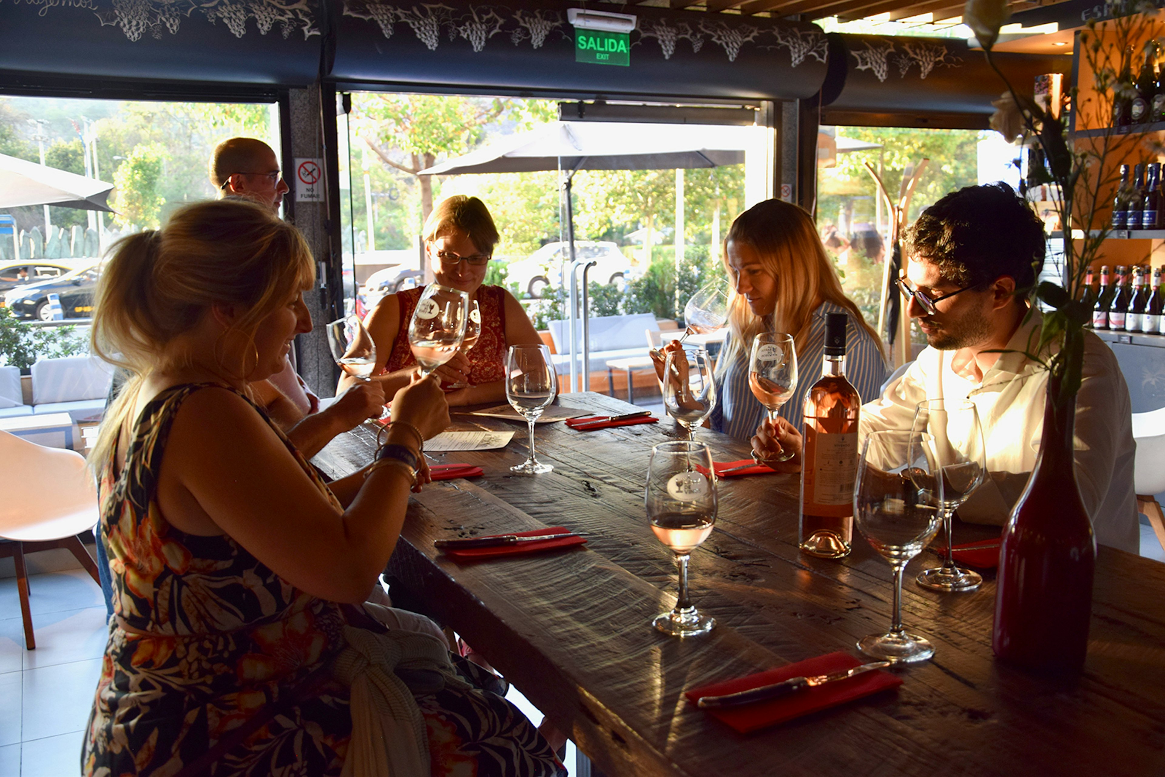 A group of people sit at a table drinking rose wine in Santiago, Chile