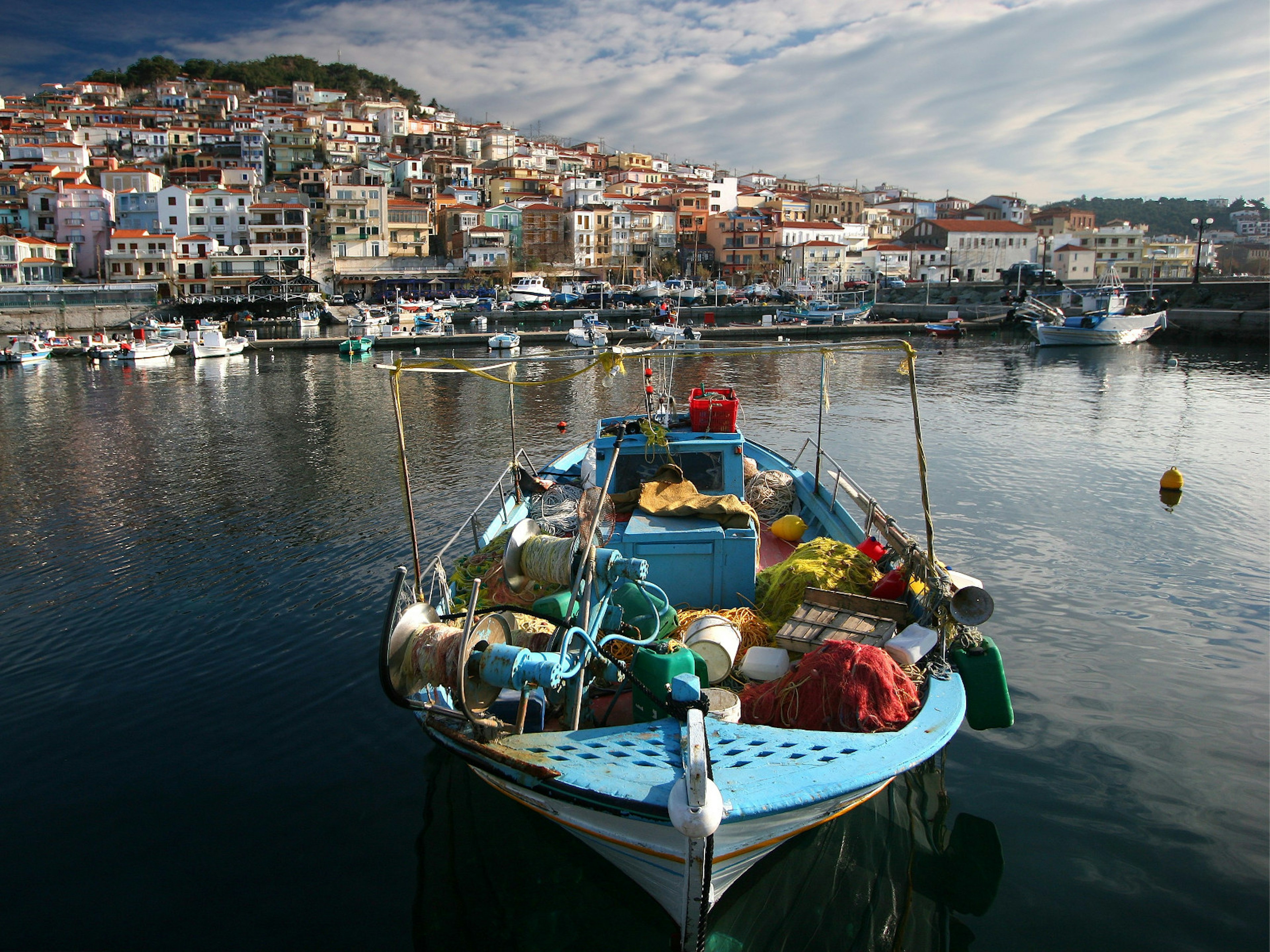 A fishing boat laden with nets lolls in the harbour on the island of Lesvos © Tan Yilmaz / Getty Images