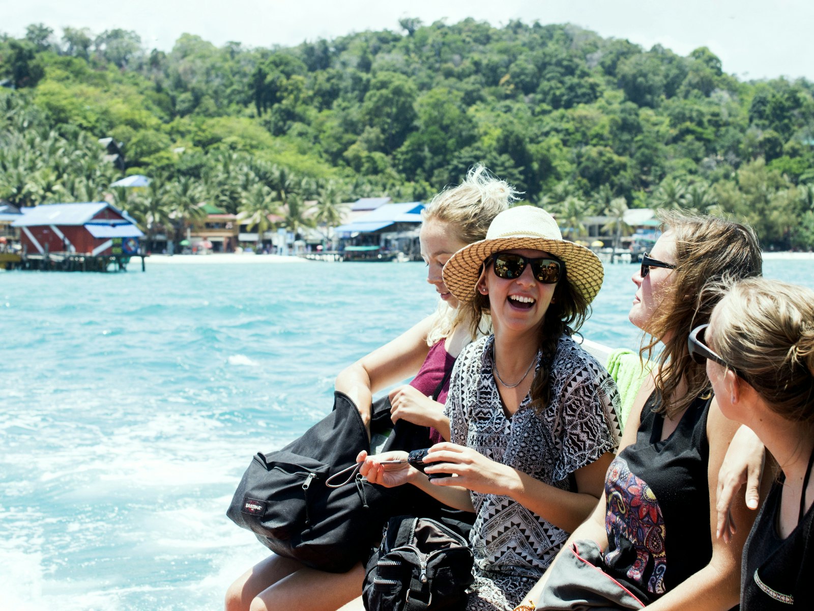 Four girls laughing by the ocean in Cambodia