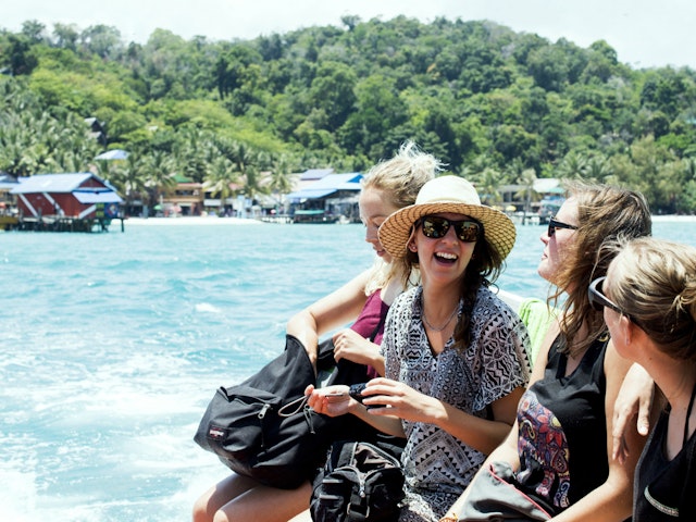 Four girls laughing by the ocean in Cambodia