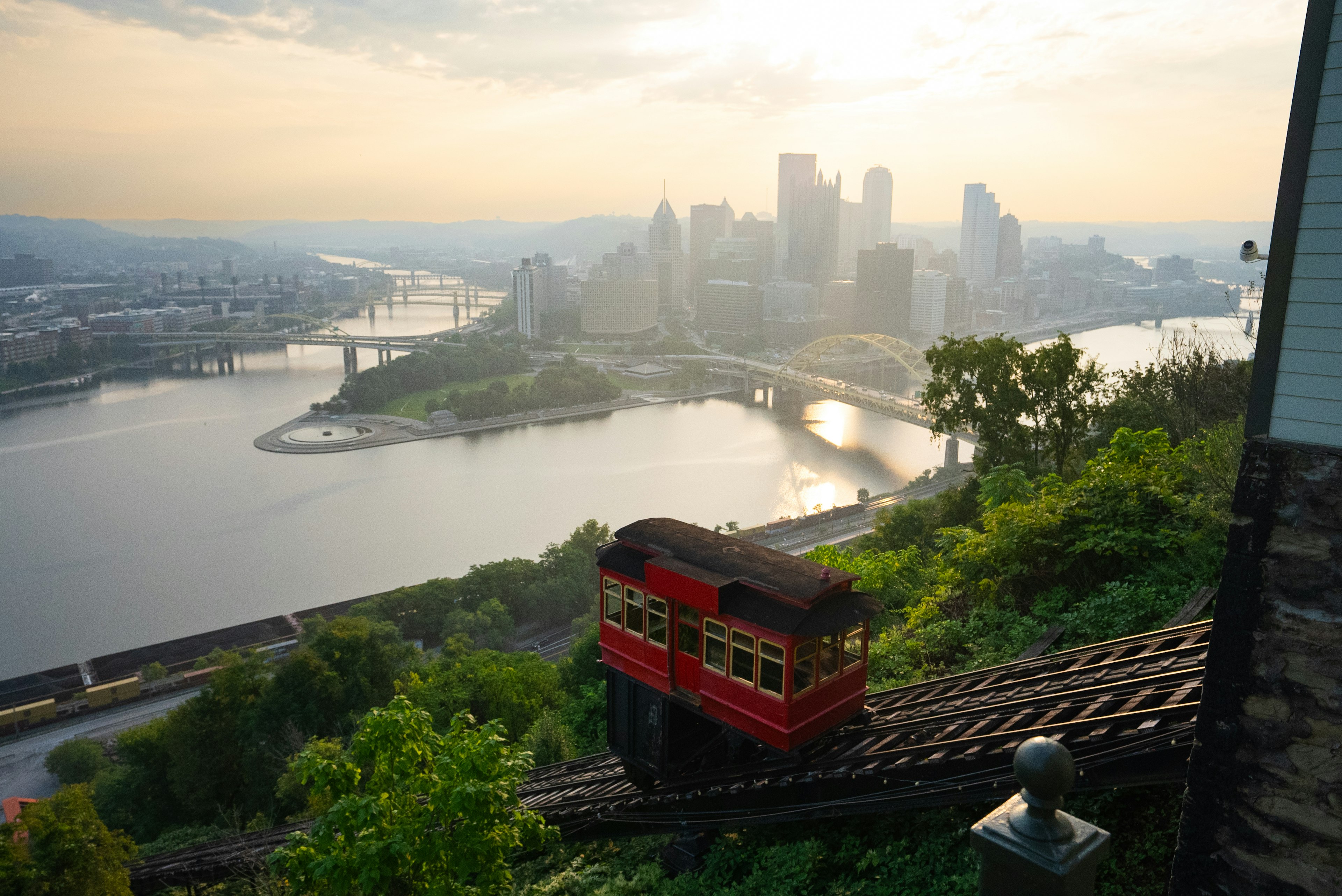 Exterior wide shot of the Duquesne Incline funicular descending from Mt Washington to Station Square, with Downtown Pittsburgh and Point State Park in the background
