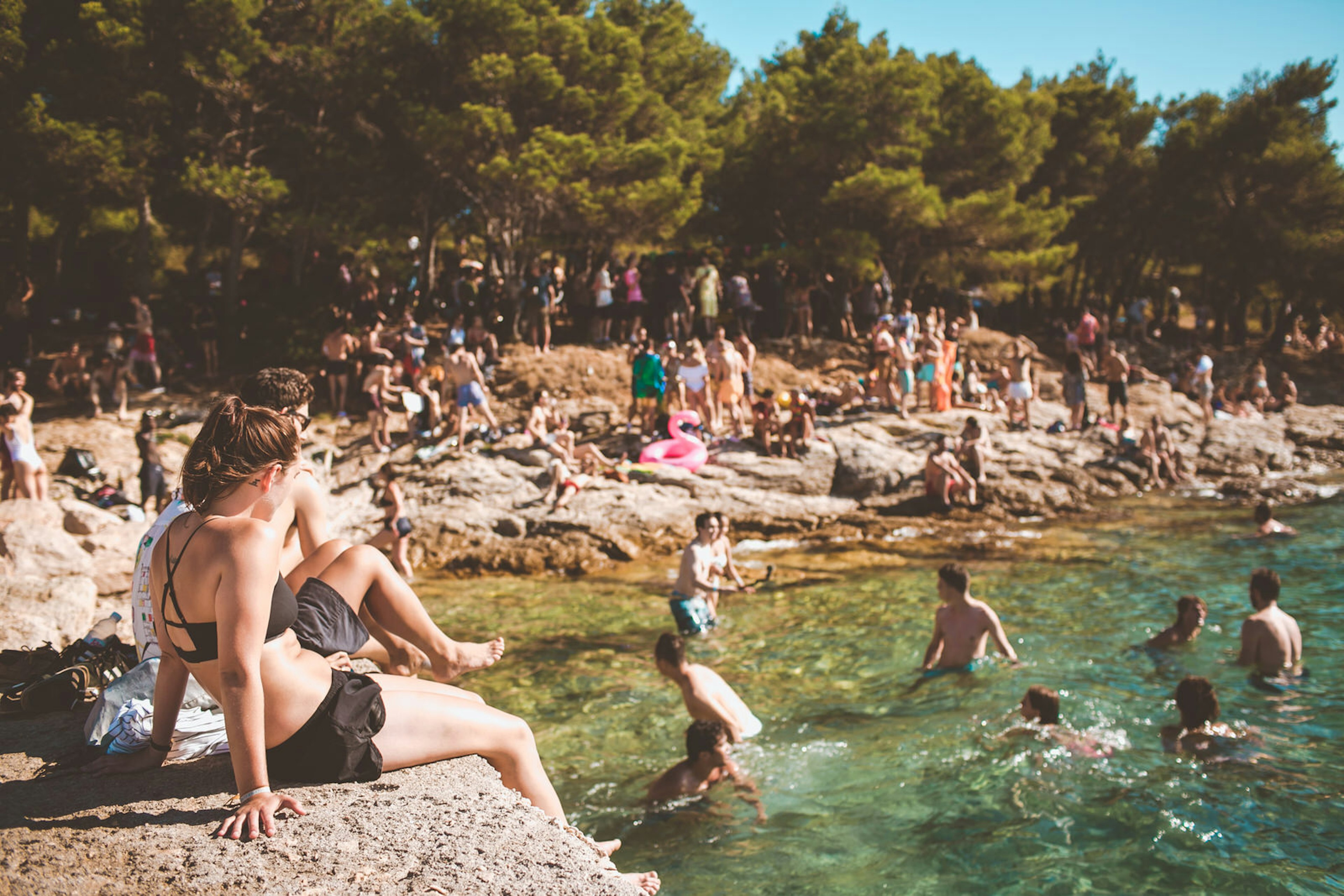 Europe music festival - people swim in the sea off the coast of a small island at Love International © Love International / Khris Cowley