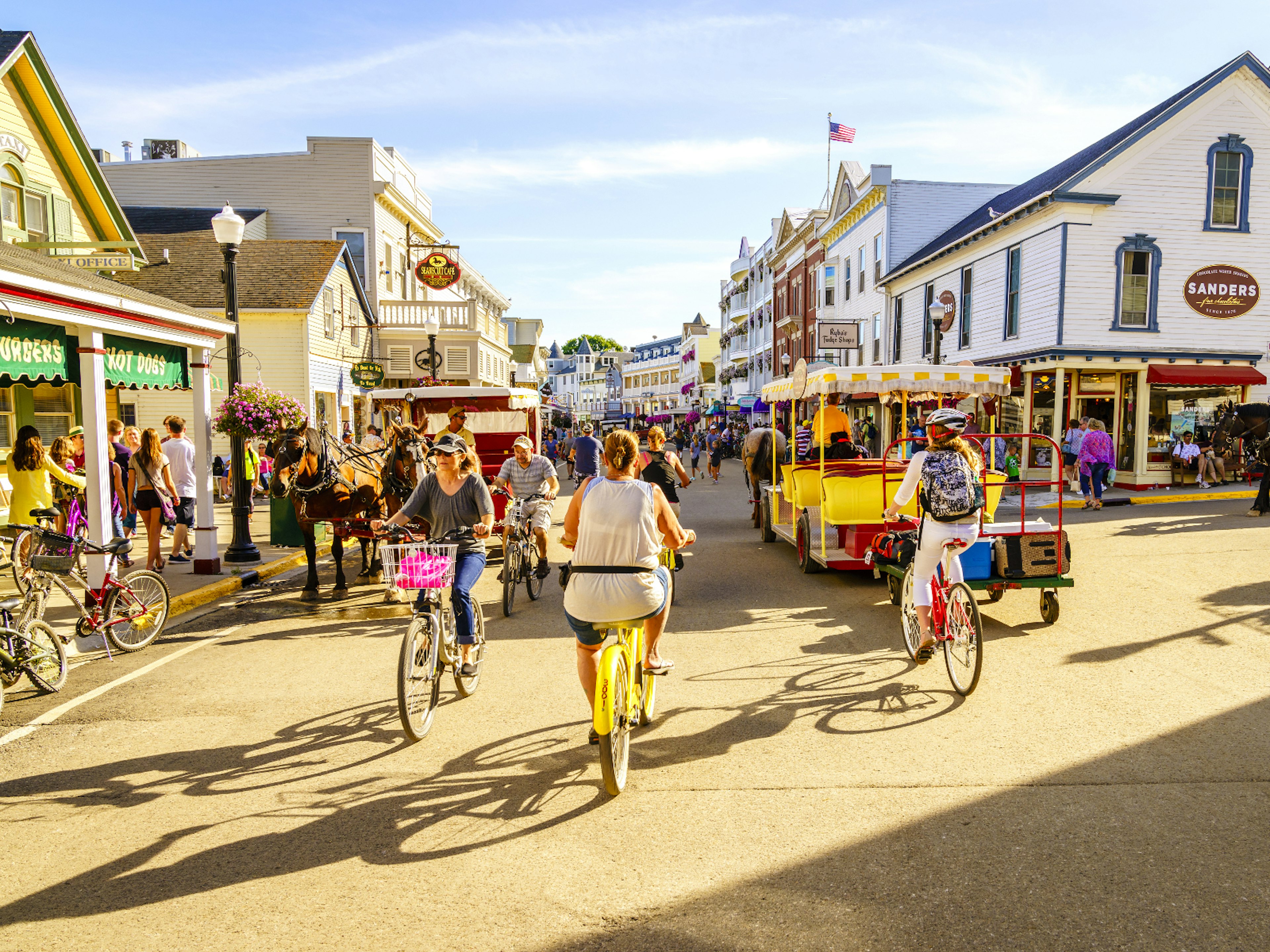 People cycling down the old-timey main street on Mackinac Island