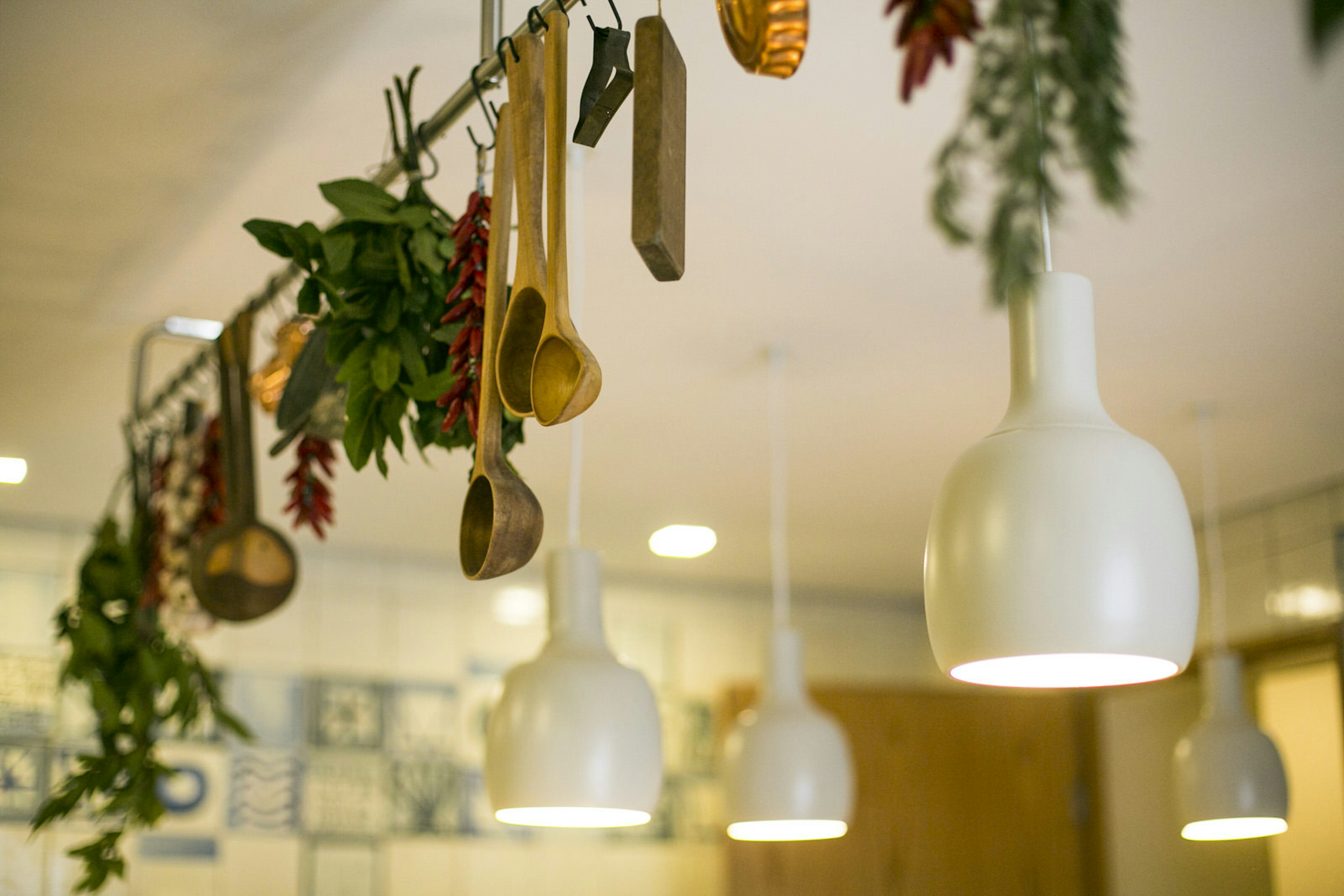 Interior of traditional Lisbon restaurant, Mao-Cheia, with wooden utensils and foliage hung from the ceiling