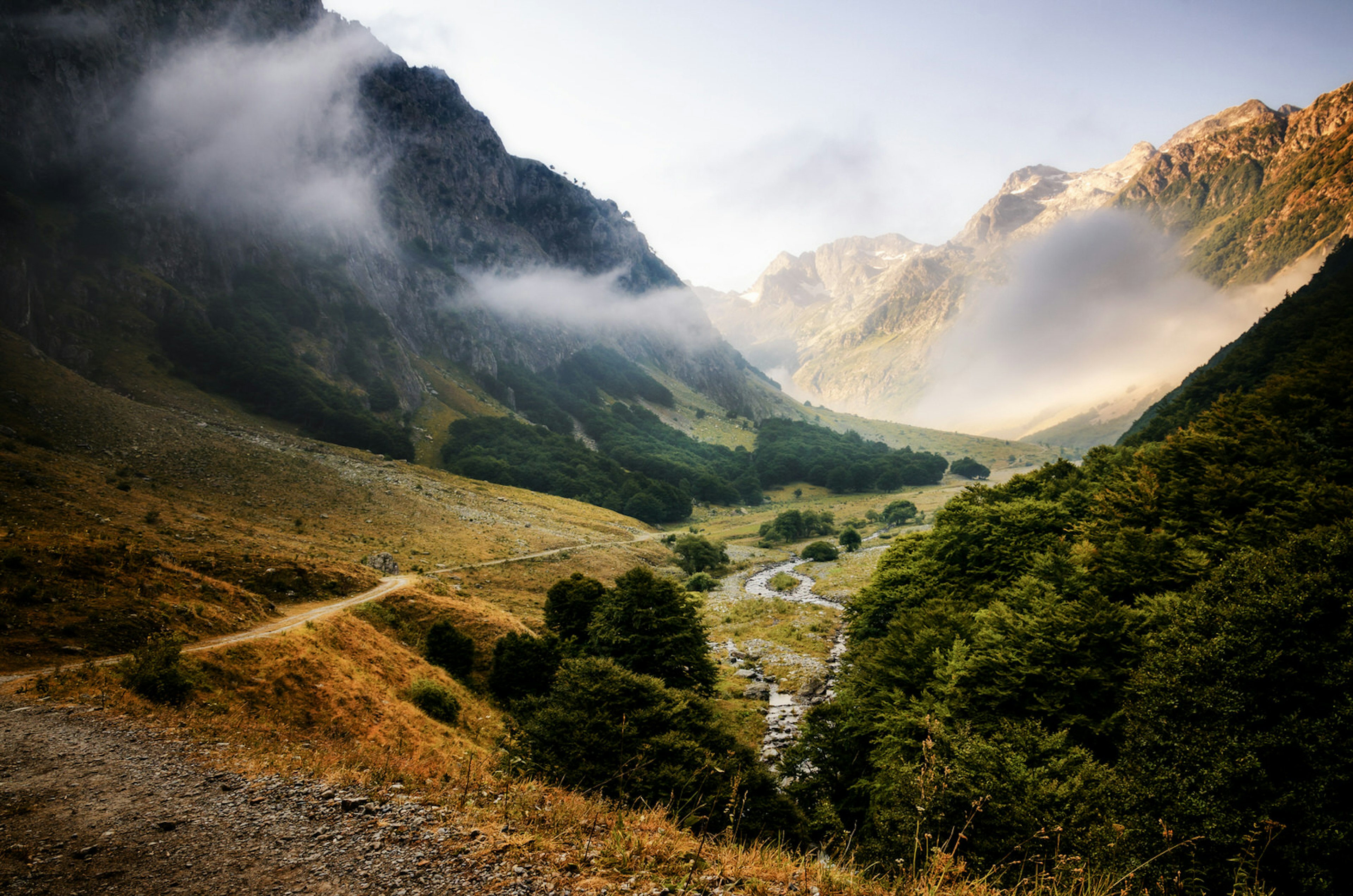 A rugged valley, wreathed with clouds and flanked by craggy mountains © Cristiano Alessandro / Getty Images