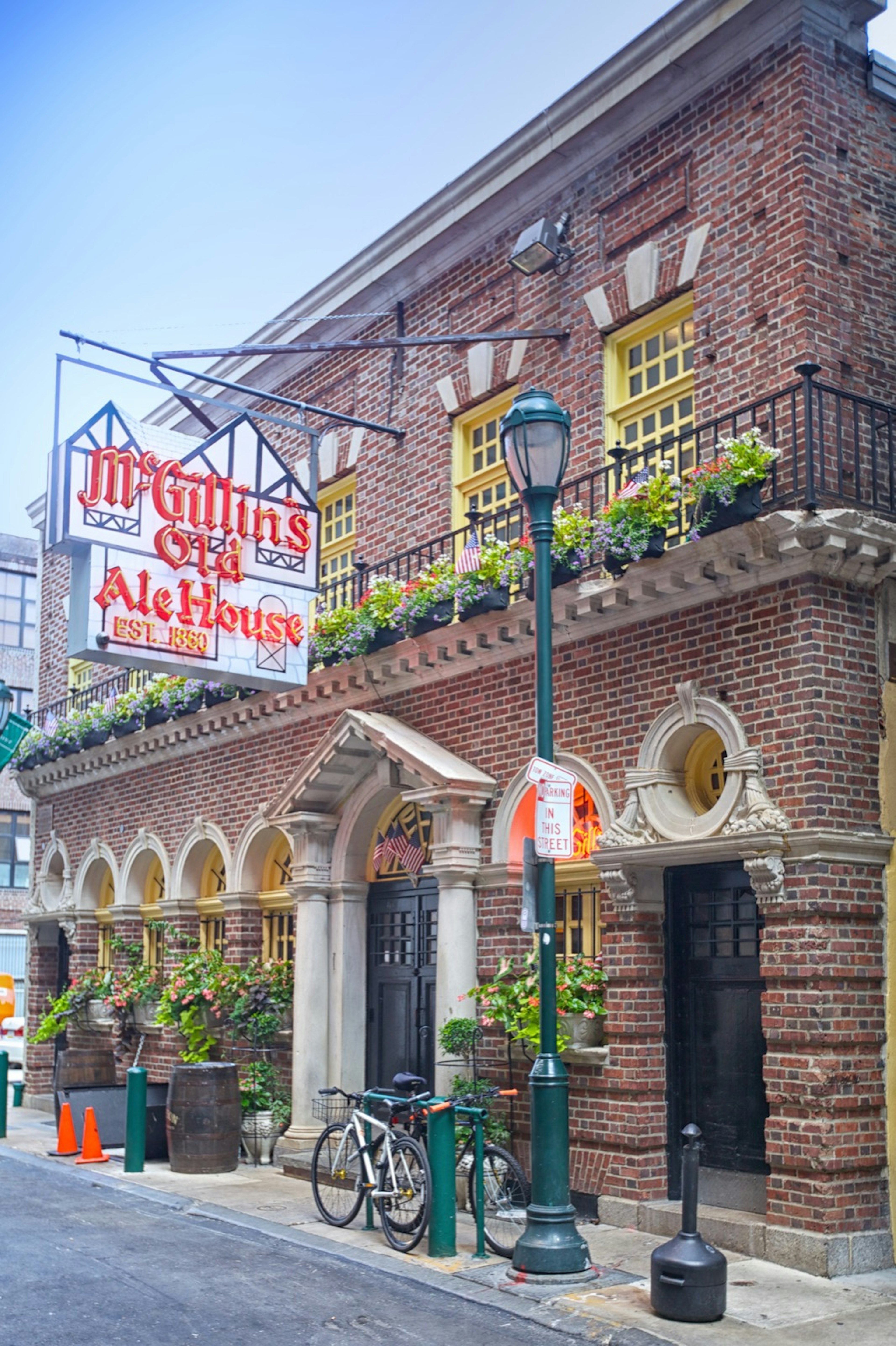 The exterior of McGillin's Olde Ale House features a pretty balcony, gas lamp and a very large neon sign