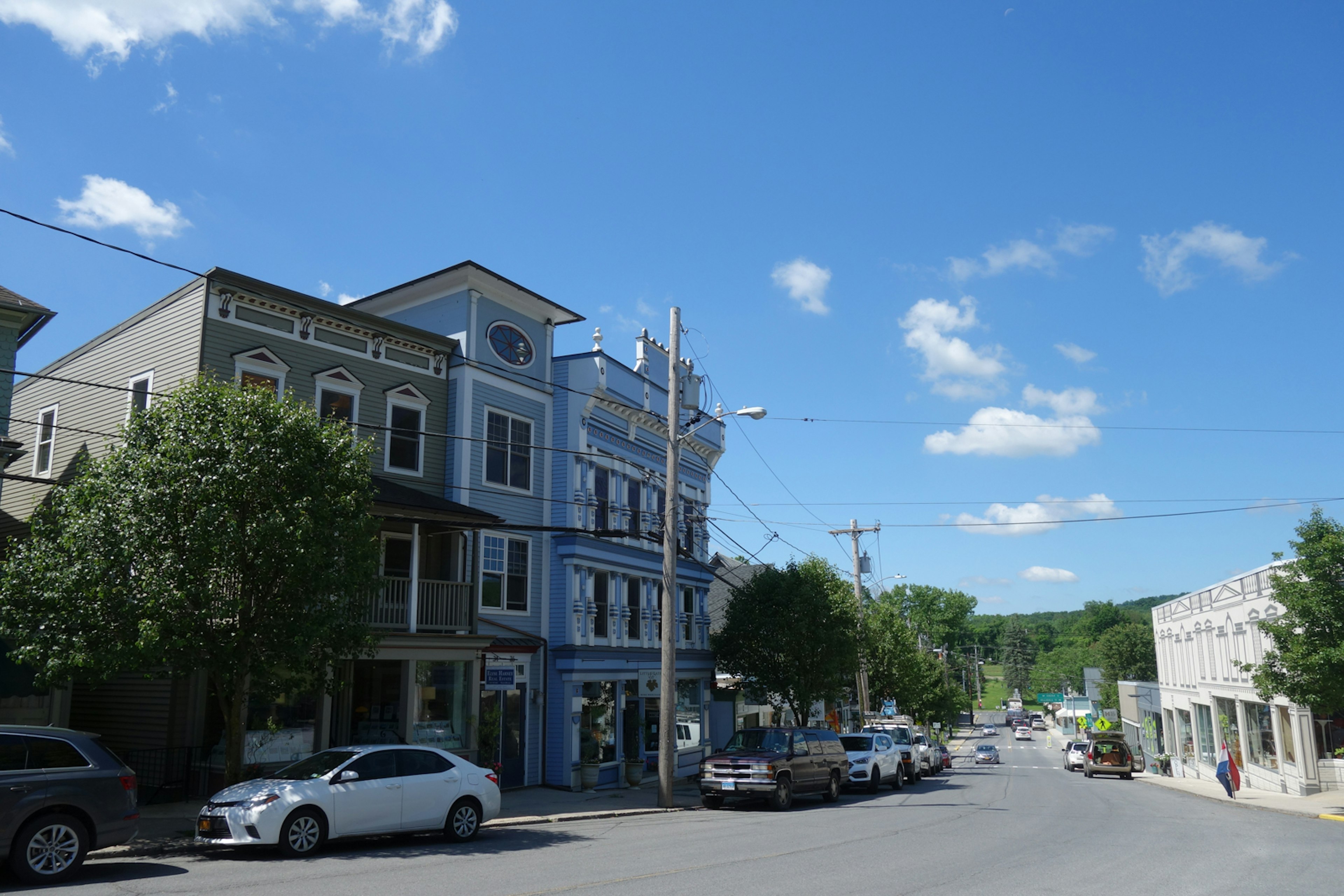 A small downtown street, with blue skies above; summer trips from New York City