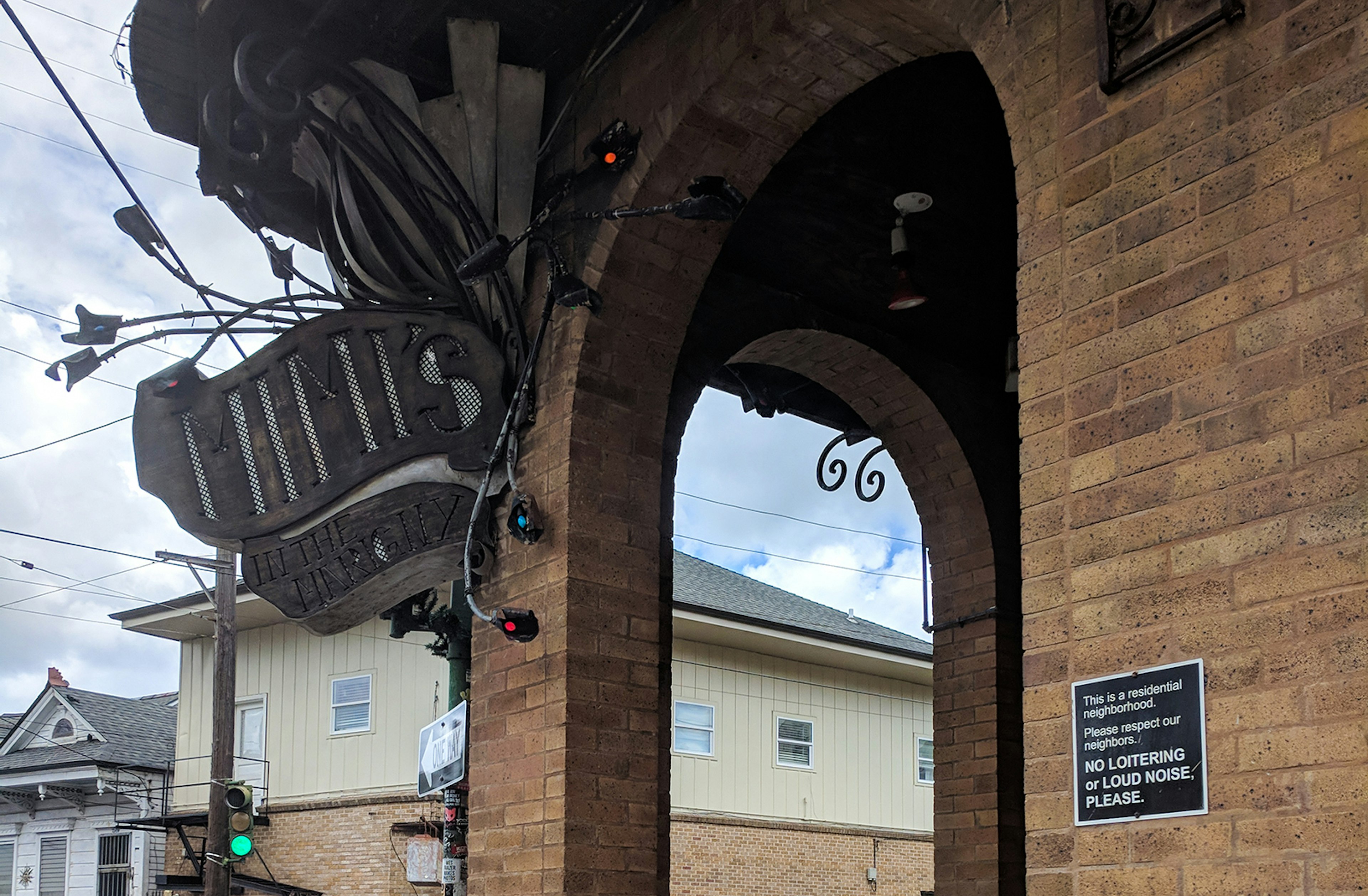 brick exterior and ornate metal sign for Mim's in the Marigny in New Orleans