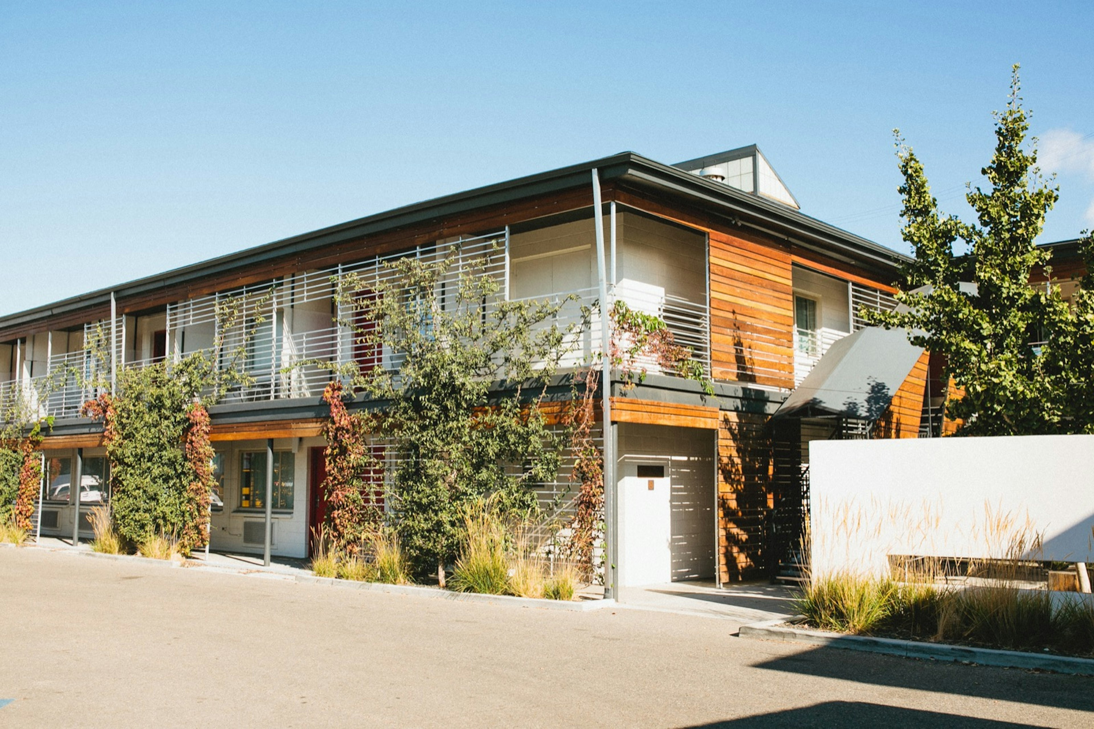 Exterior of Modern Hotel, one of America's coolest motels, with plants on trellises and wood panels under a blue sky