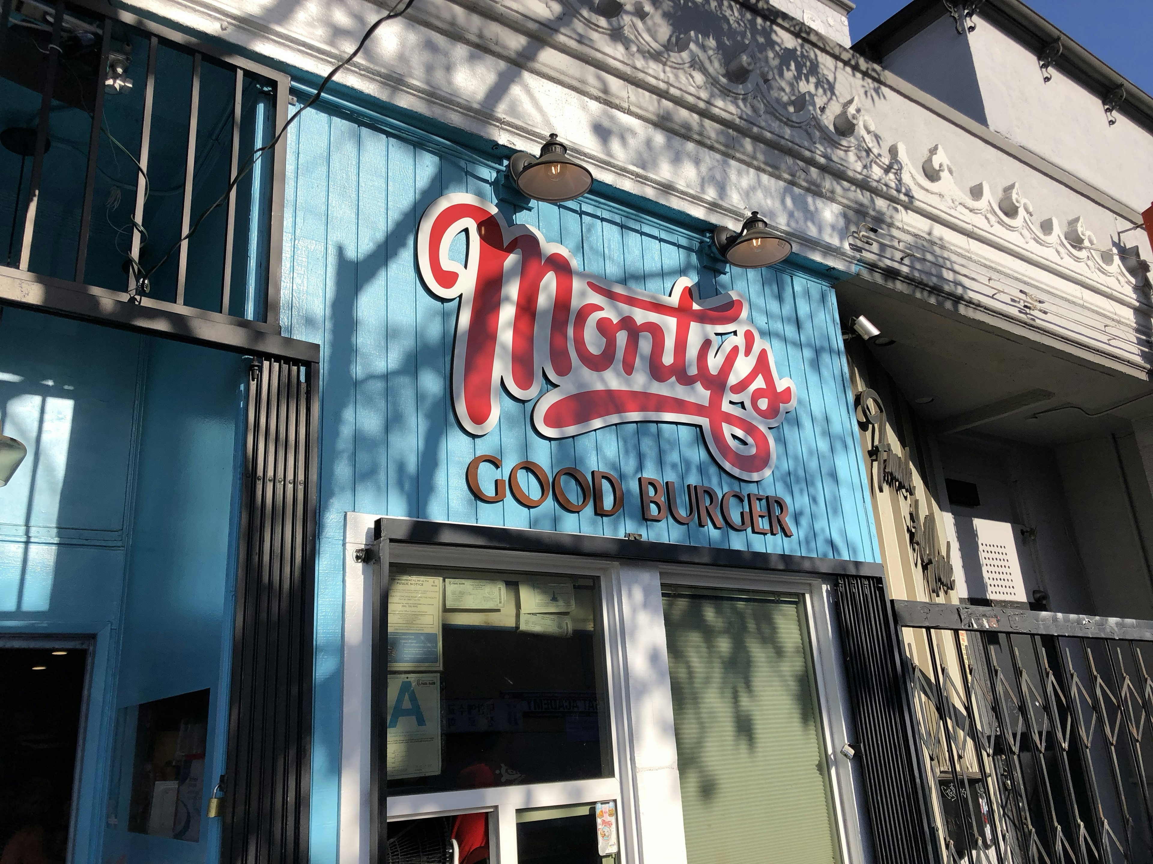 The exterior of Monty's Good Burger, featuring blue wooden paneling with red and white lettering of the burger spot's name; LA vegan restaurants