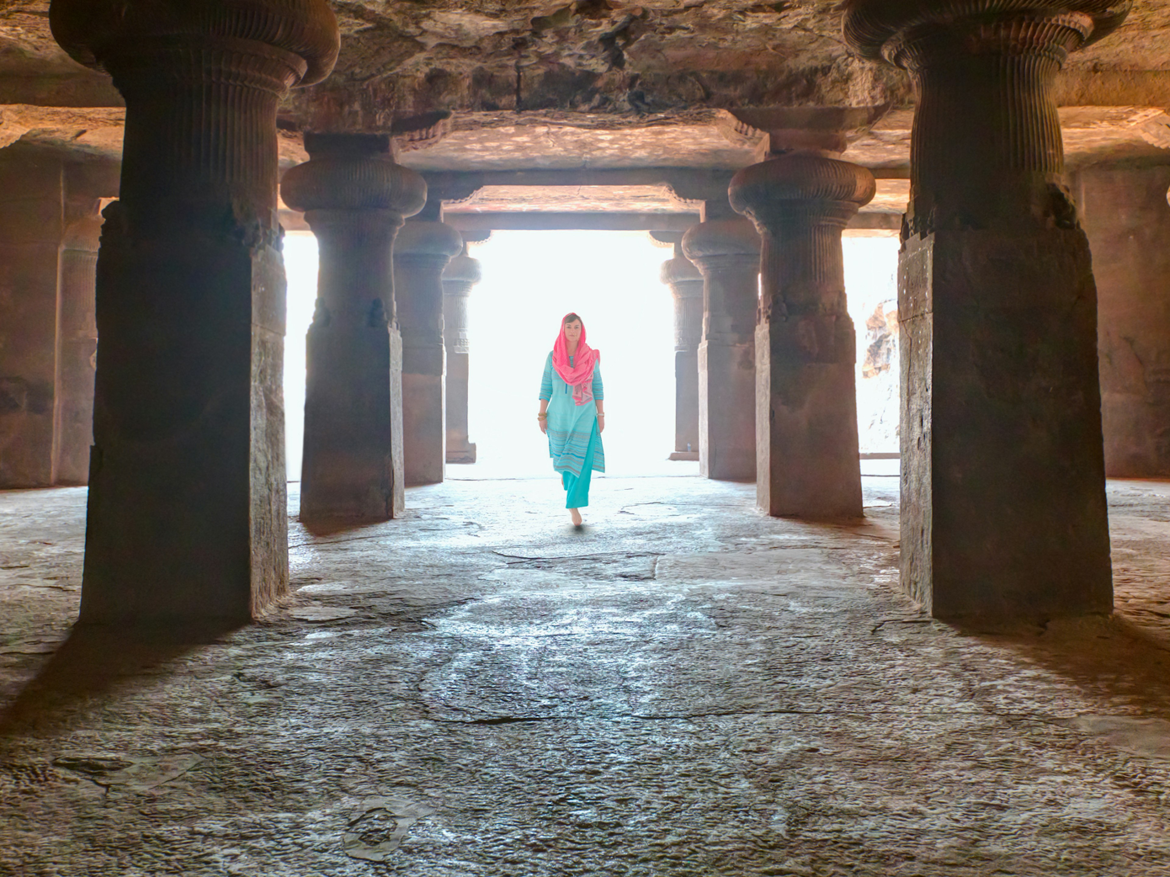 An Indian woman dressed in a sari walks in the temple on Elephanta Island, Mumbai