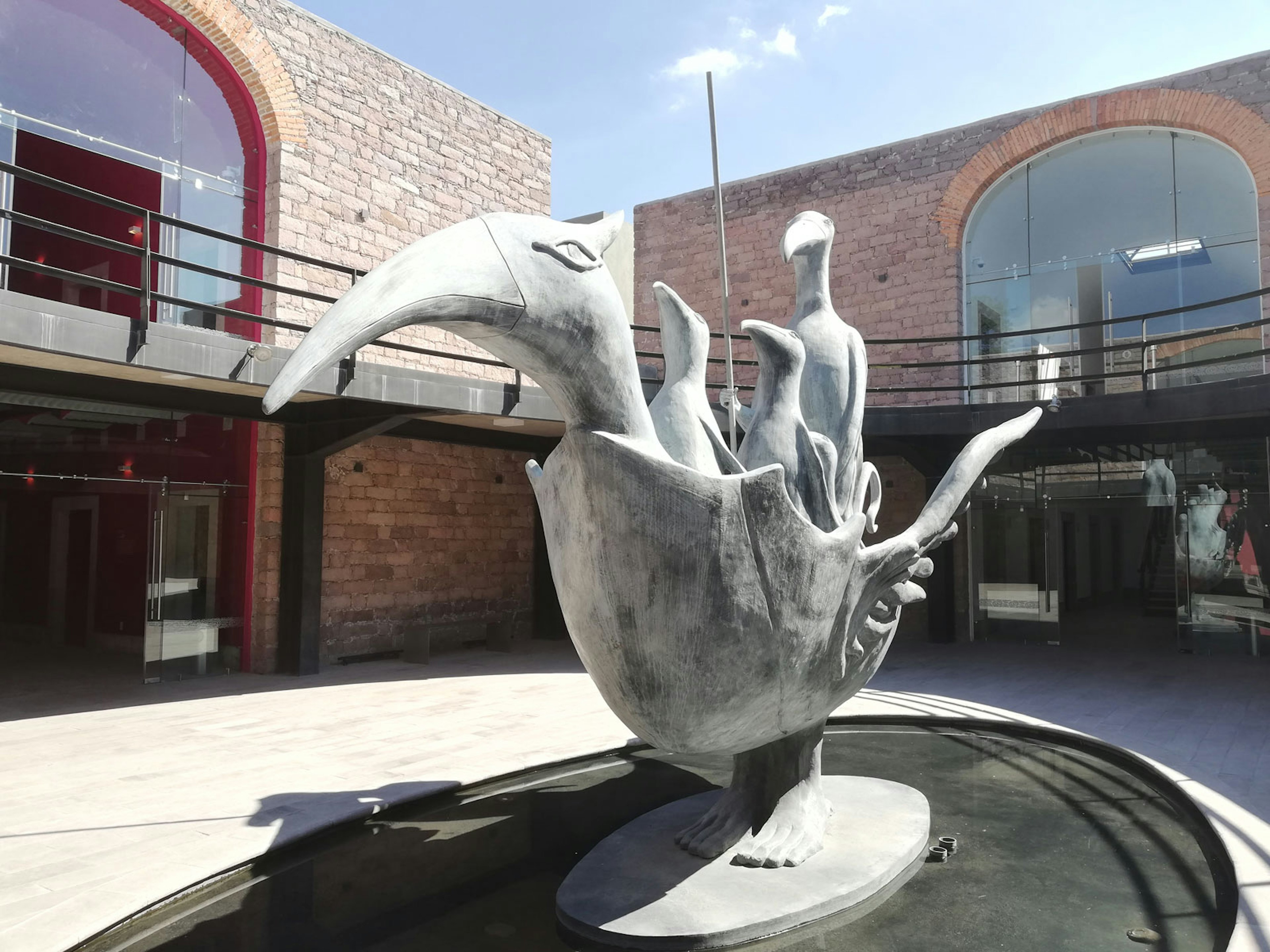 A sculpture of a bird rowing a boat that is shaped like a bird