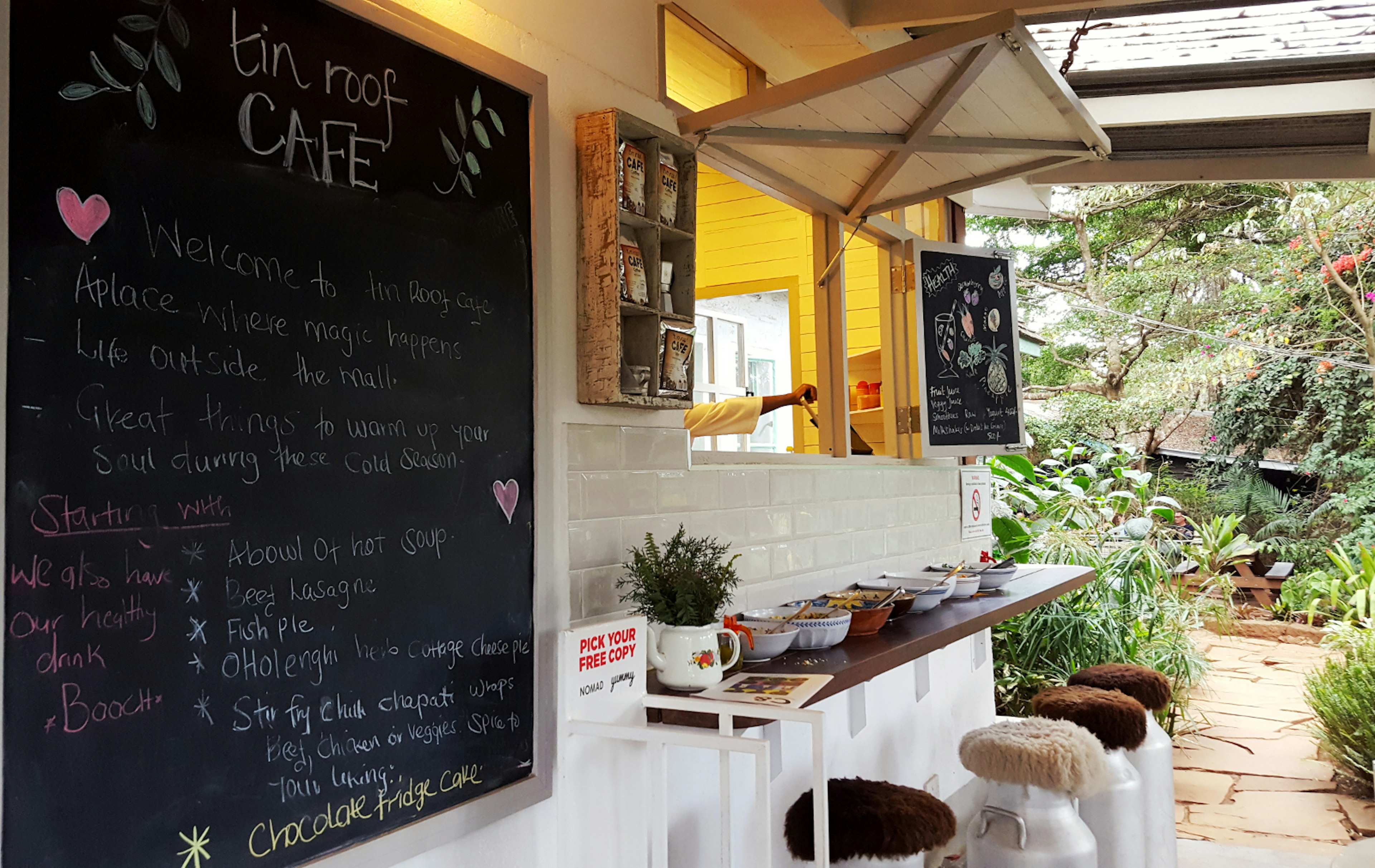 A welcoming open window is set above some bar seating (stools made of industrial milk containers with sheepskin cushions) in the outdoor section of the Tin Roof Cafe, one of Nairobi's 10 best independent cafes © Clementine Logan / ϰϲʿ¼