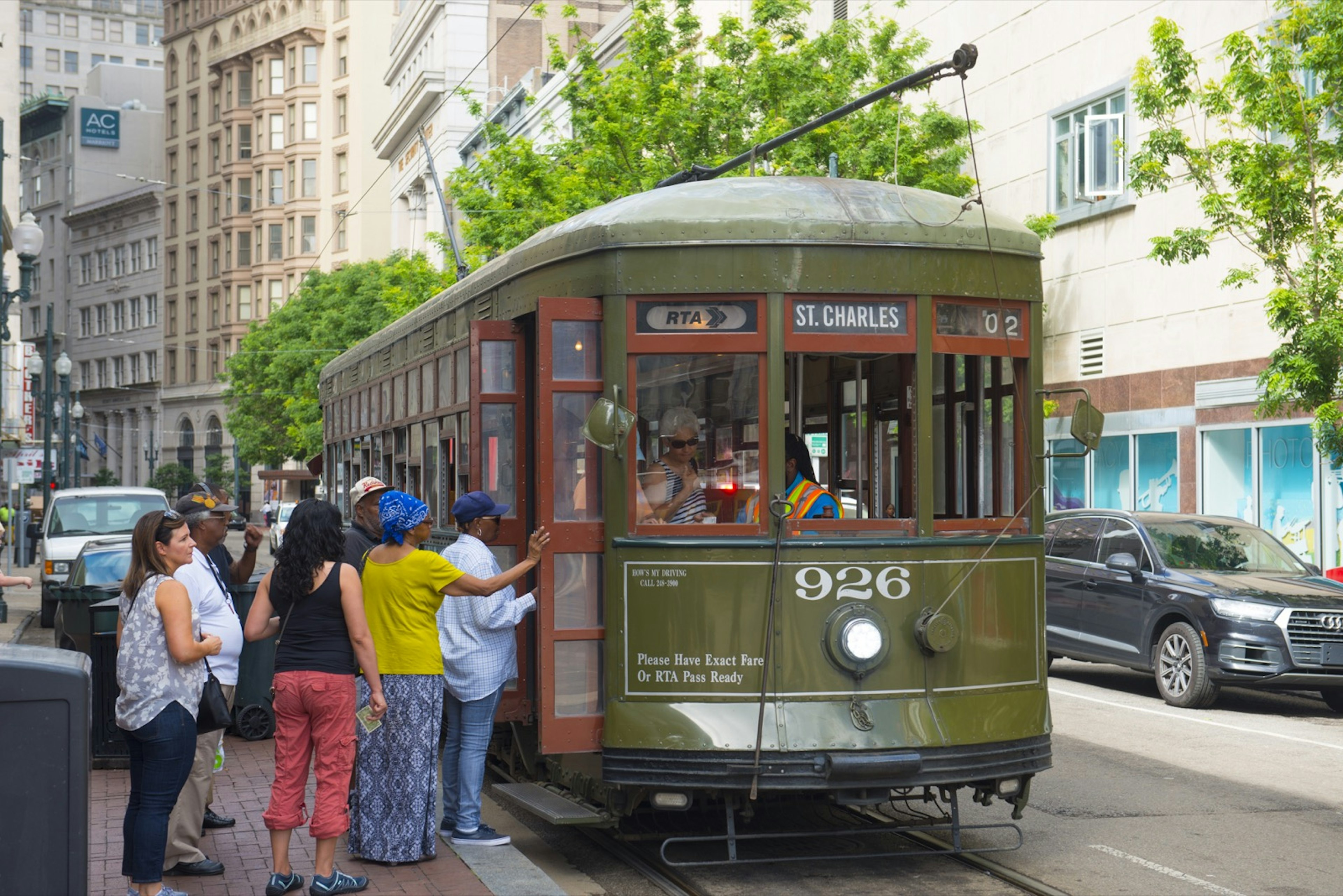 People board an olive green antique streetcar at St. Charles Line Route 12 on Canal Street in downtown New Orleans. The streetcar is the perfect way to get around during a New Orleans weekend.