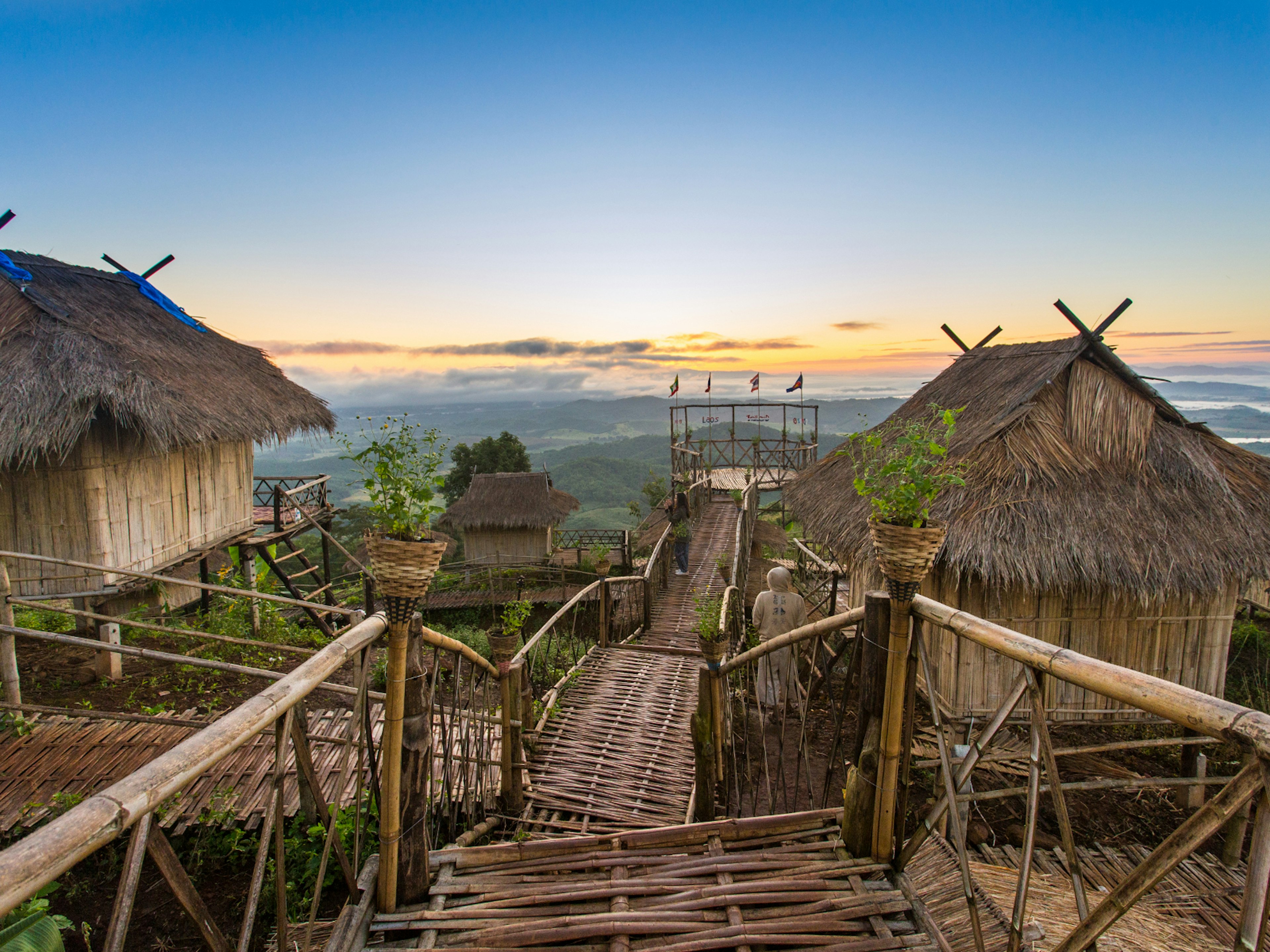 Viewpoint in Chiang Rai made of wooden walkways, with two wooden houses on stilts, overlooking Thailand's Golden Triangle