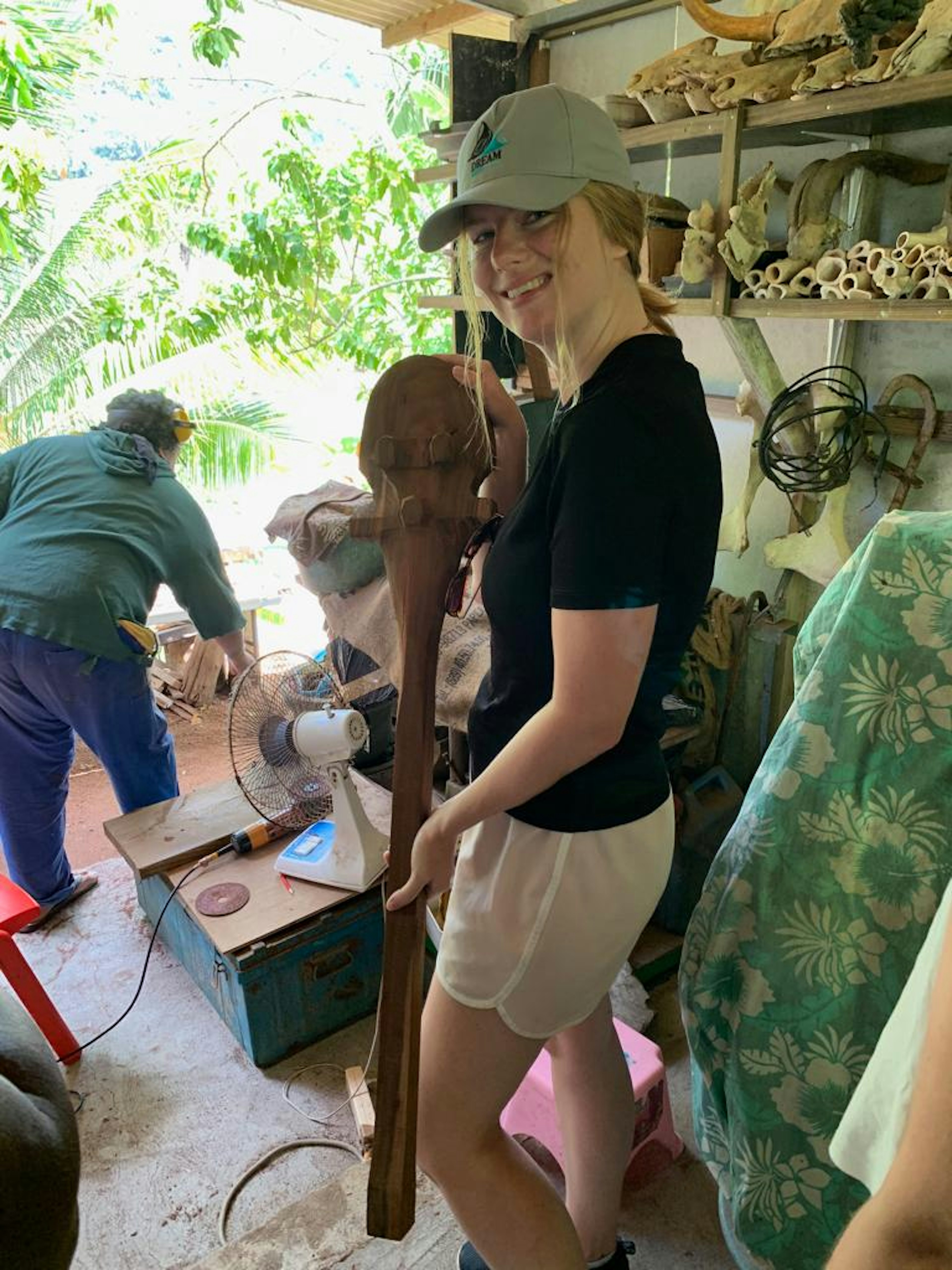 Caroline holds a wooden 'brain teaser' in a hut in Nuku Hiva