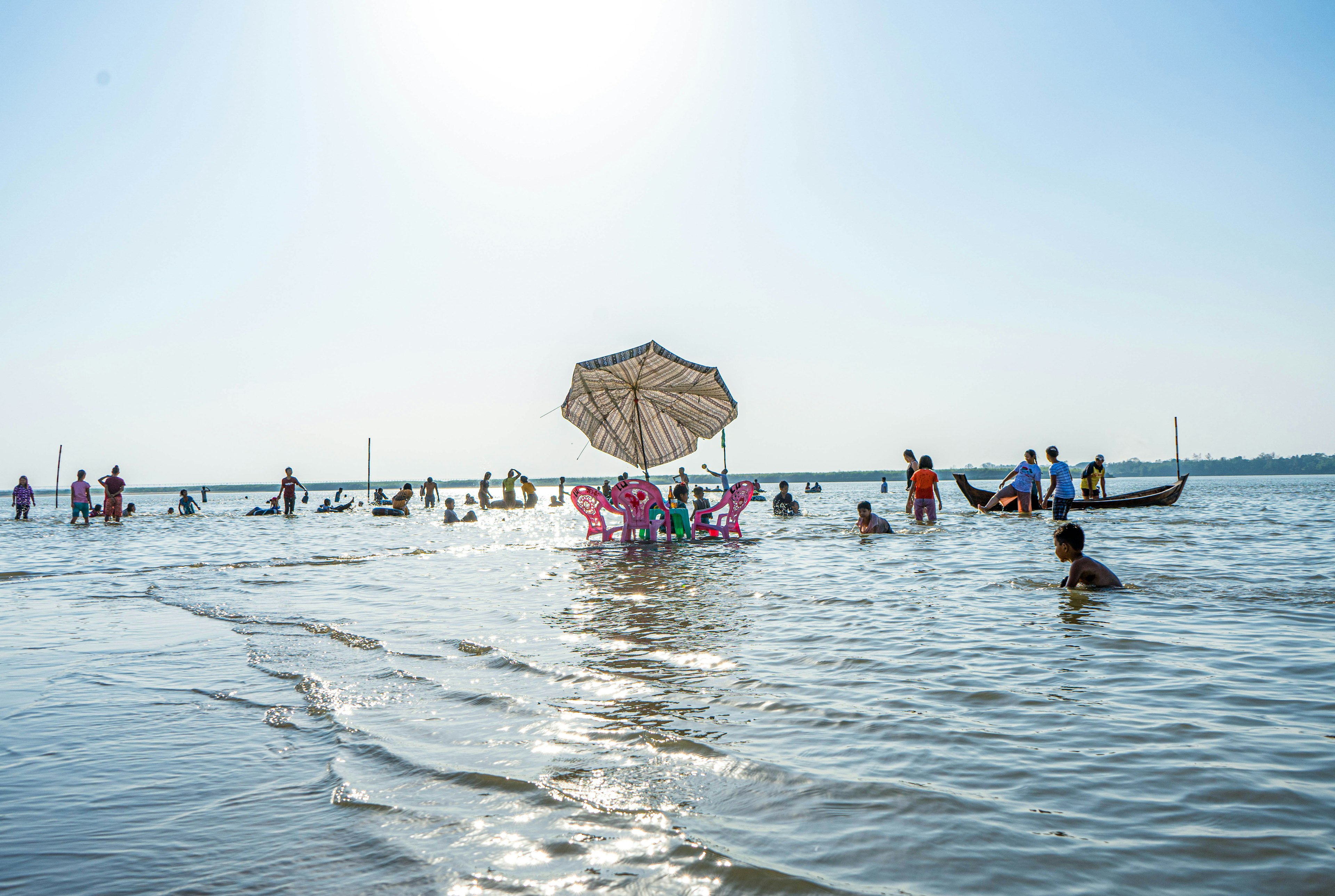 A table and three chairs are slowly submerged by the tide.