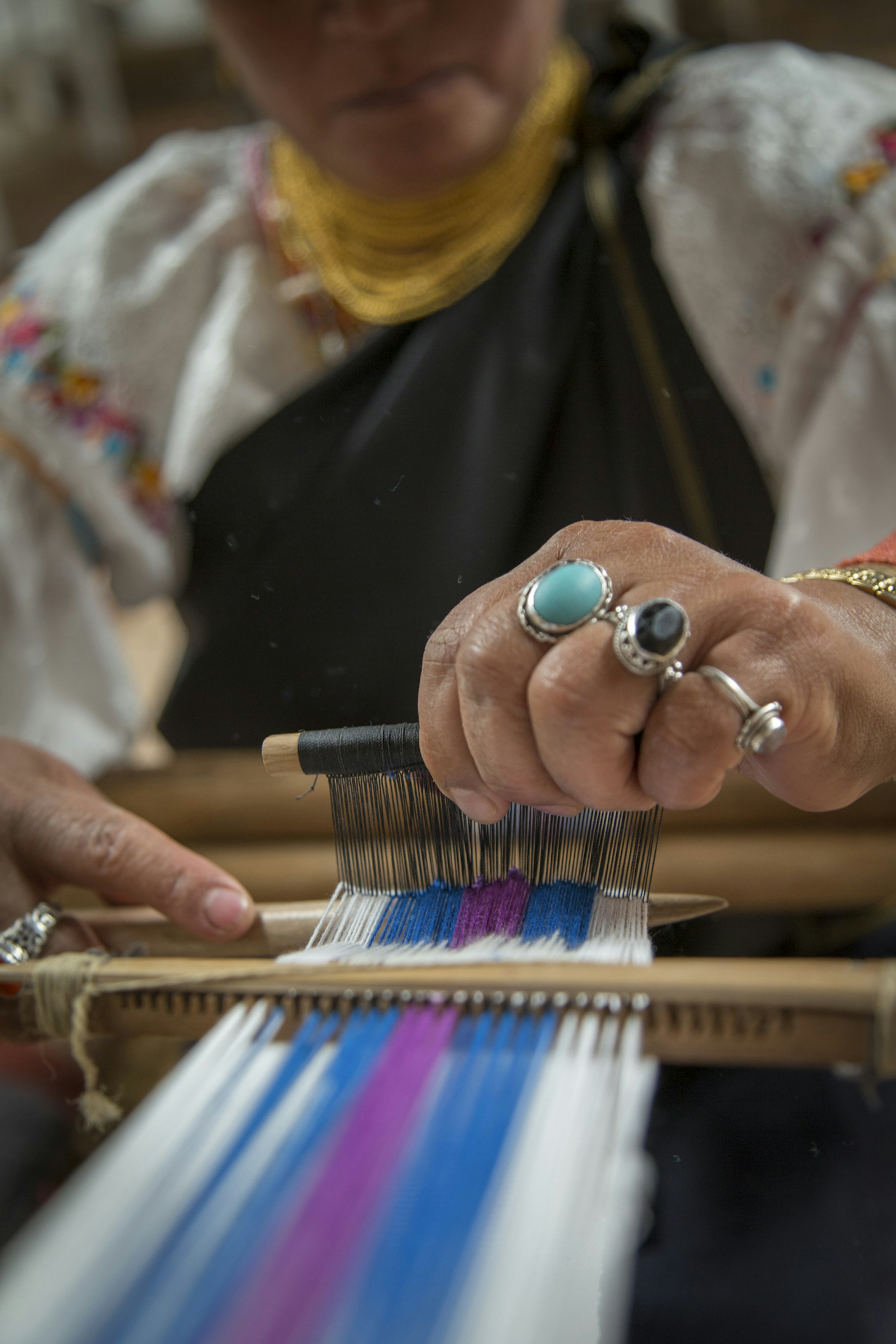 Luz Maria Andrango weaves with a backstrap loom